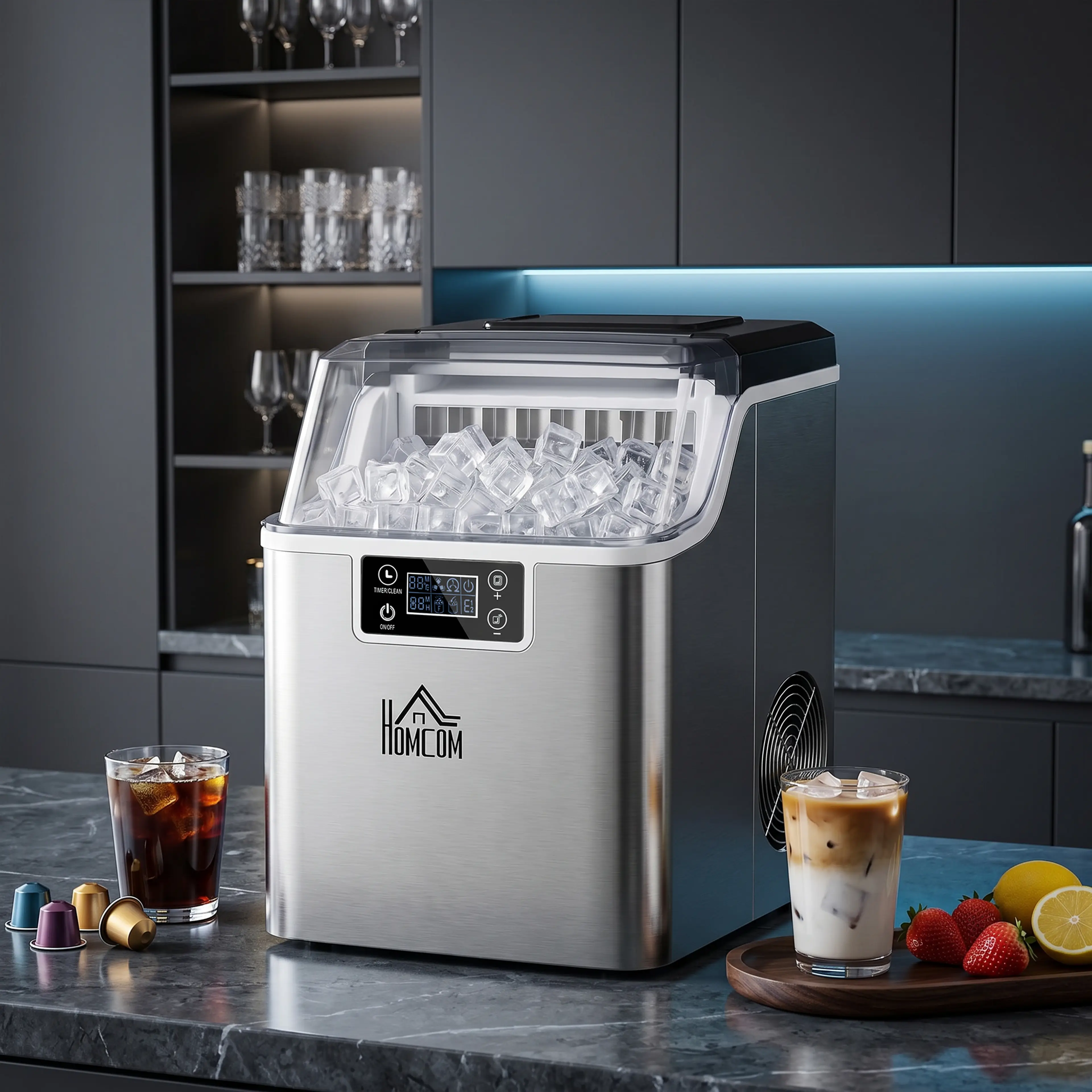 Isbitsmaskin på en mörk köksbänk med iskaffe och kolsyrad dryck i glas bredvid