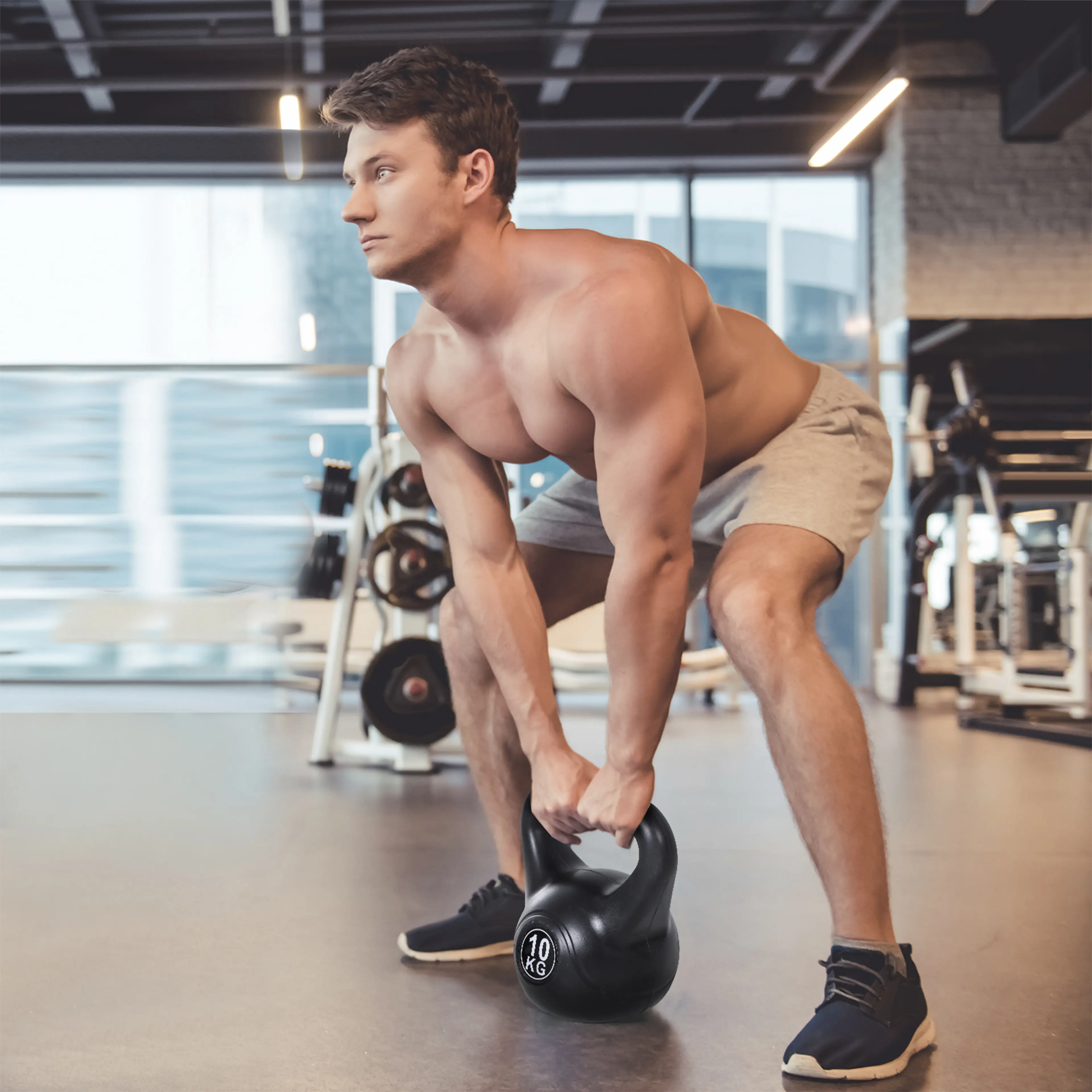 Man lyfter kettlebellen från golvet i ett gym