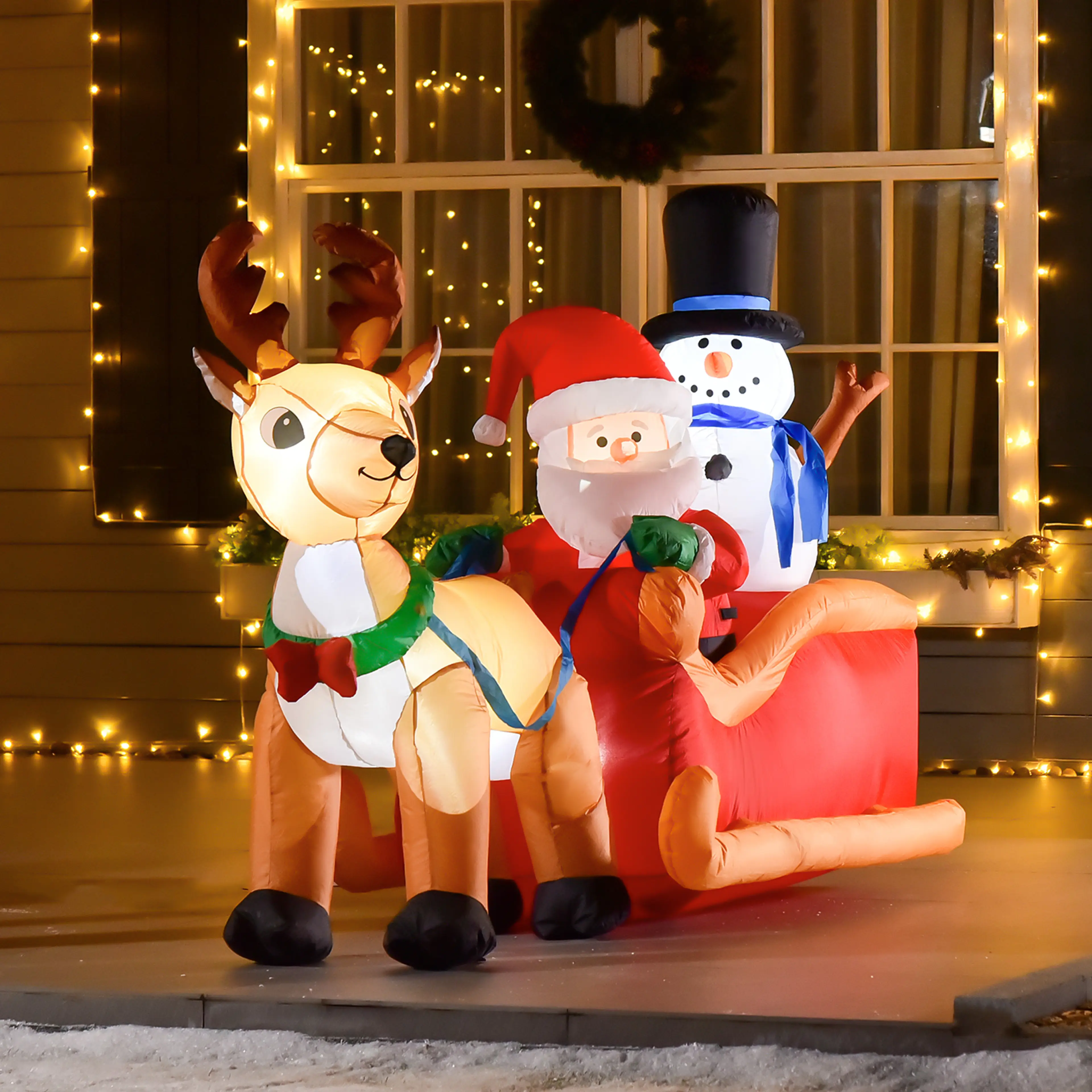 Den uppblåsta julfiguren tänd framför ett hus med julbelysning