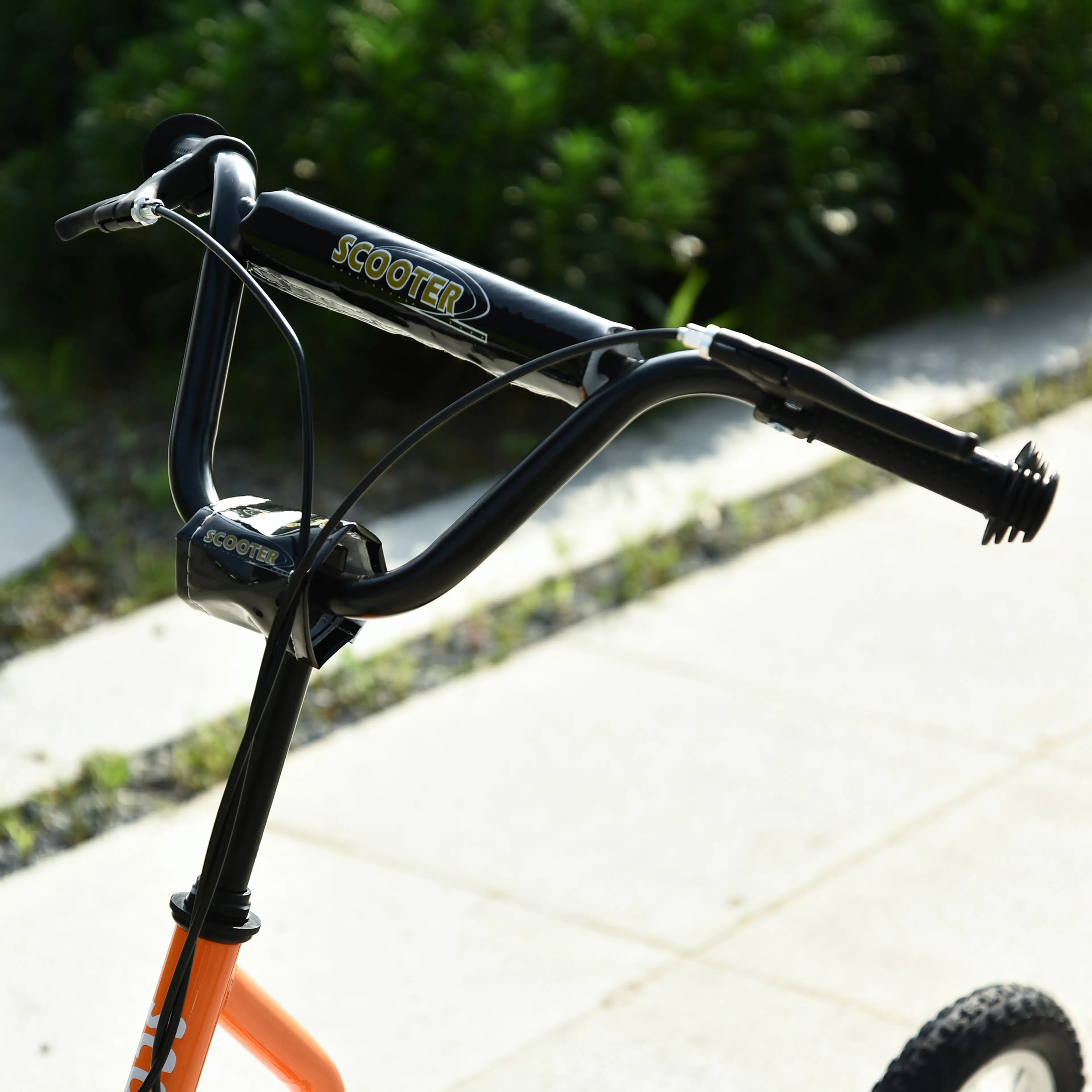 Närbild på styret och styrstammen på orange sparkcykel
