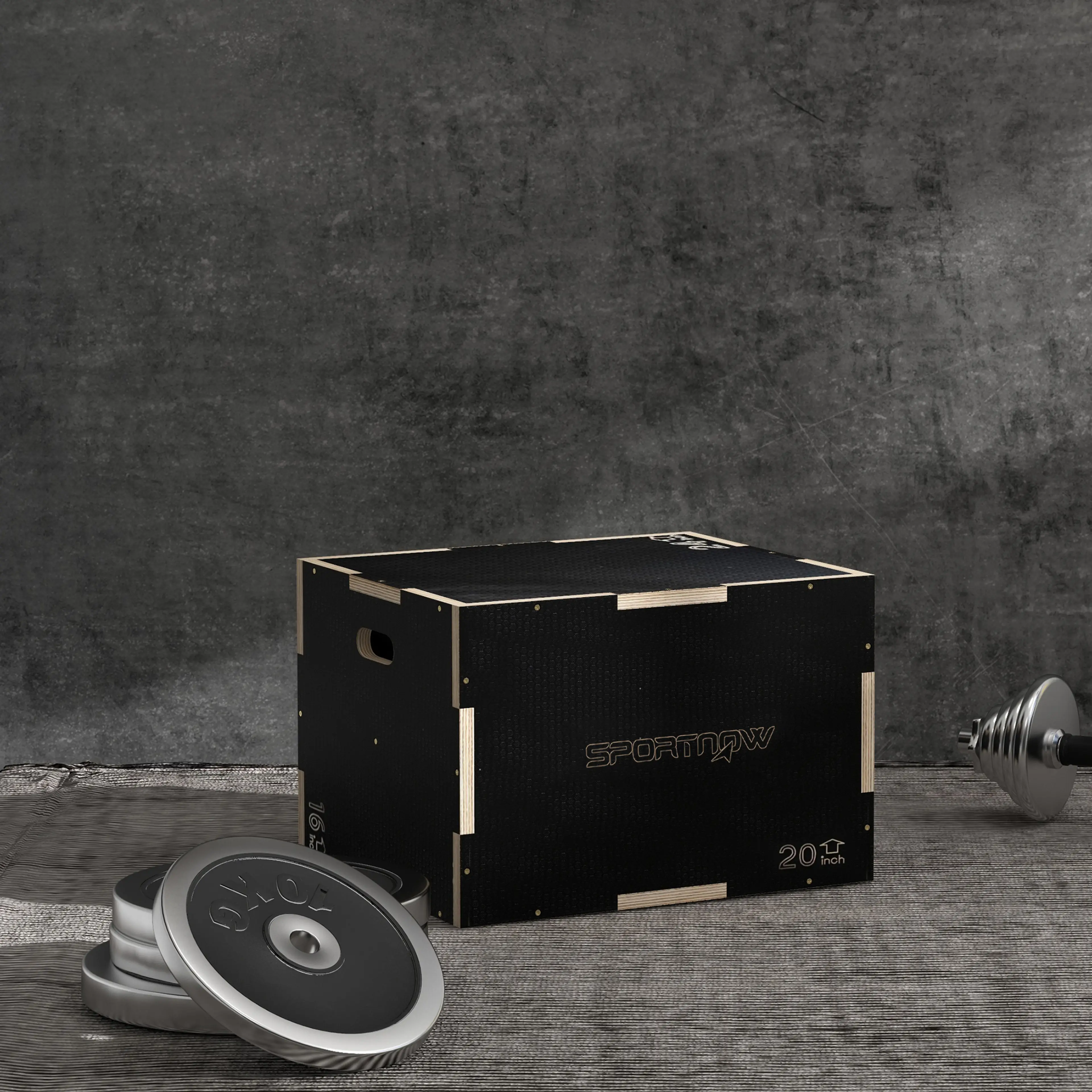 Plyo box på ett grått golv med viktskivor och en hantel bredvid