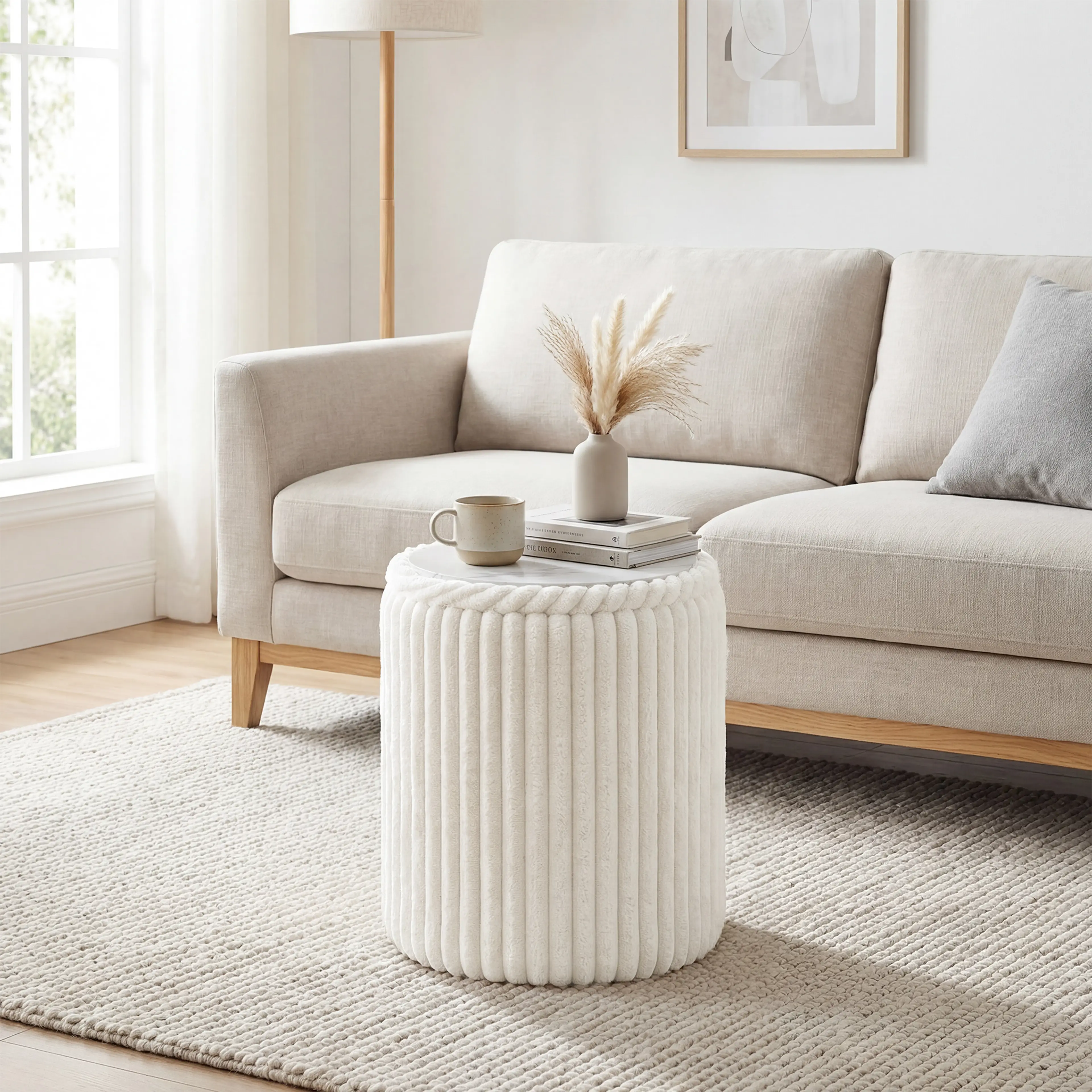 Puffen med locket vänt som bord framför en soffa, med en kopp och böcker på