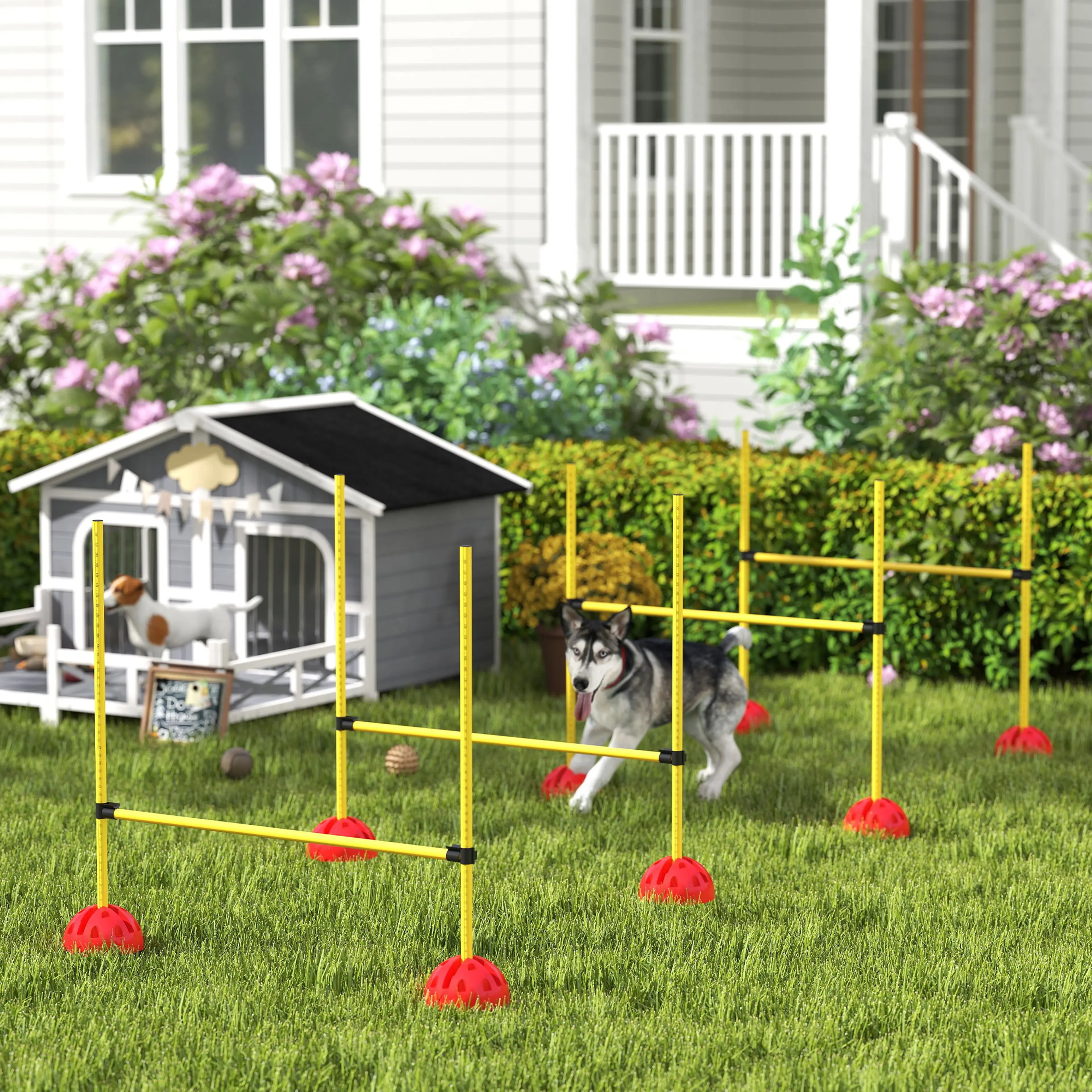 En husky hoppar över ett av hindren på en gräsmatta, med en hundkoja och blommande buskar bakom