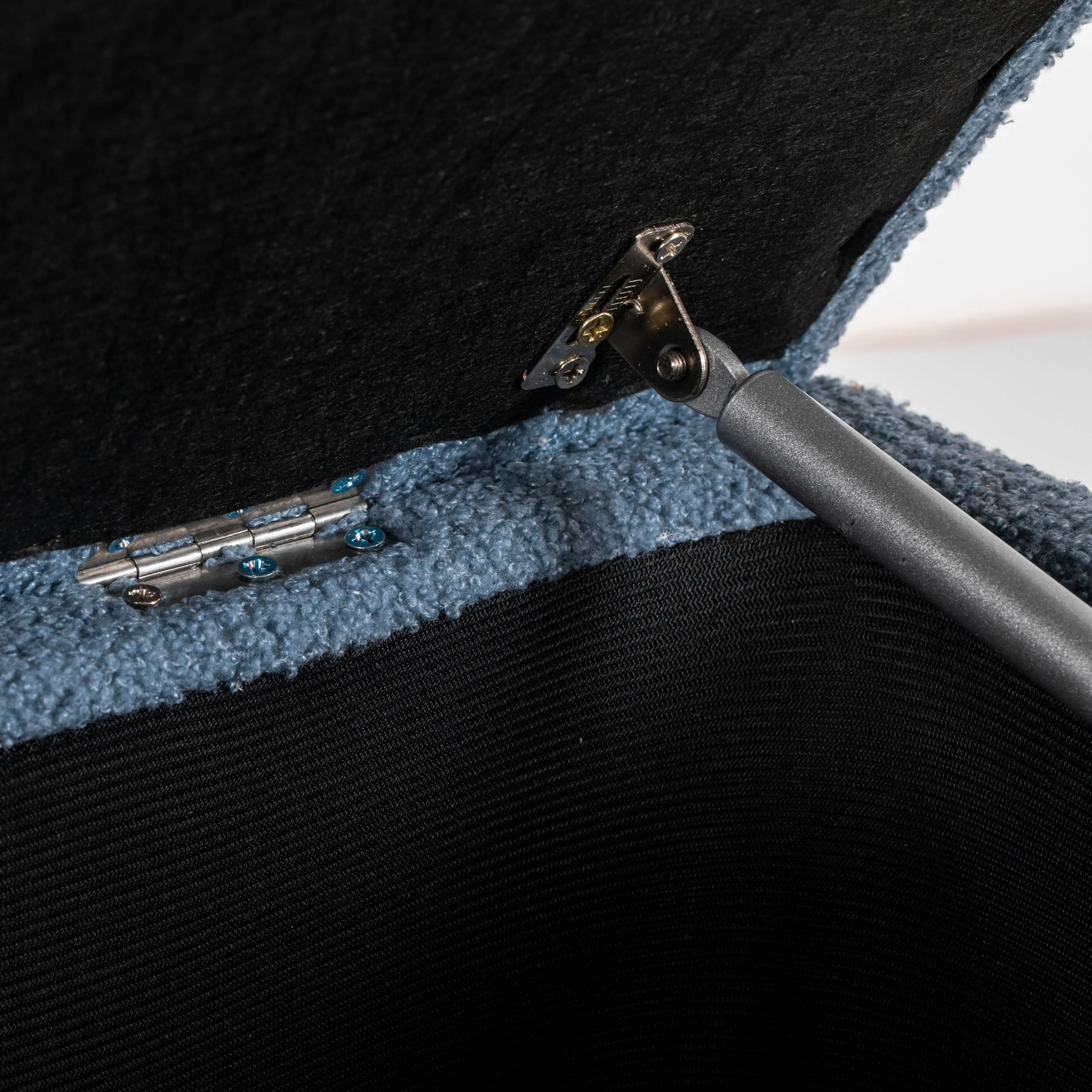 Detaljbild inifrån bänken med gaskolven och gångjärnet som bär locket