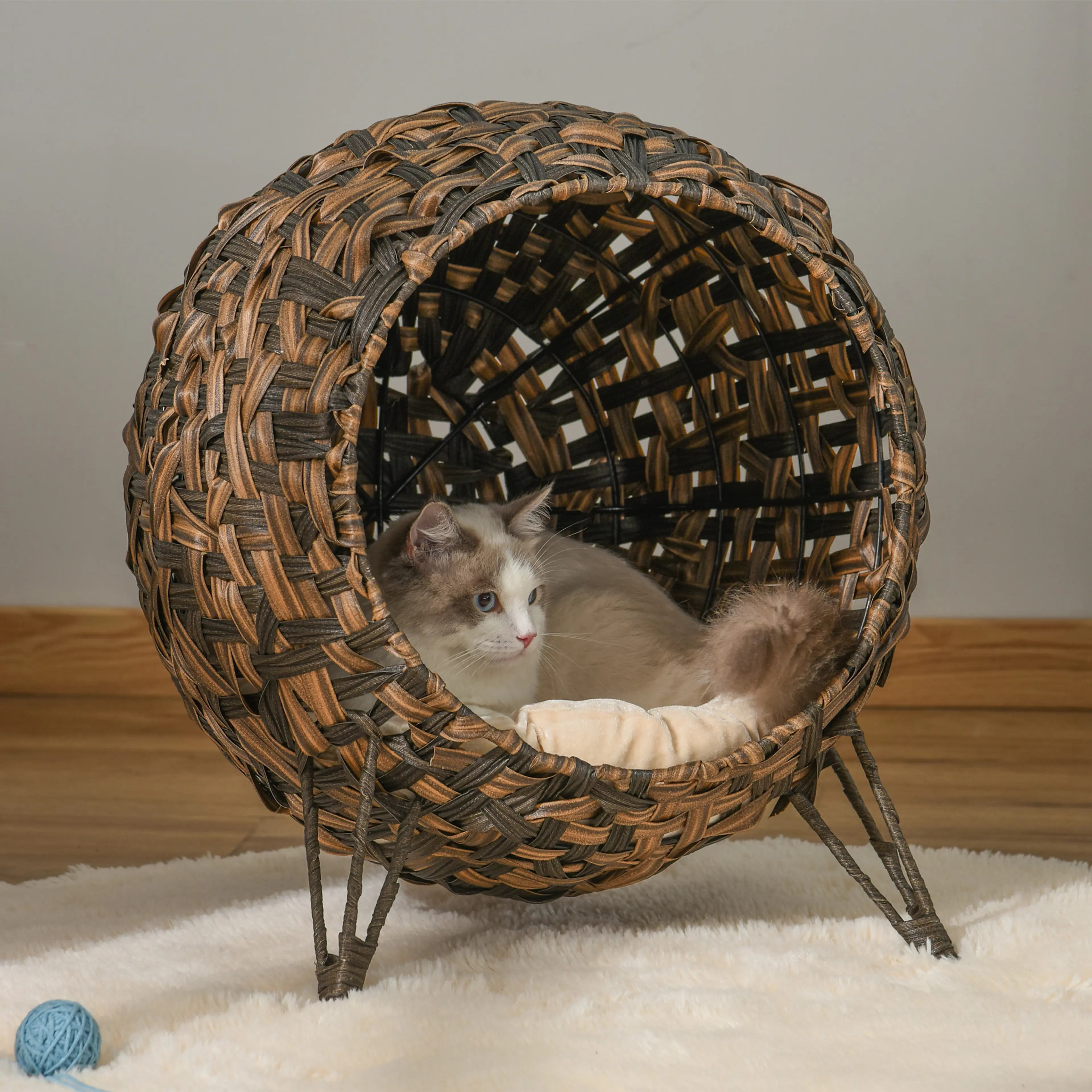 Den upphöjda kattgrottan i ett vardagsrum med en katt som ligger inne i klotet