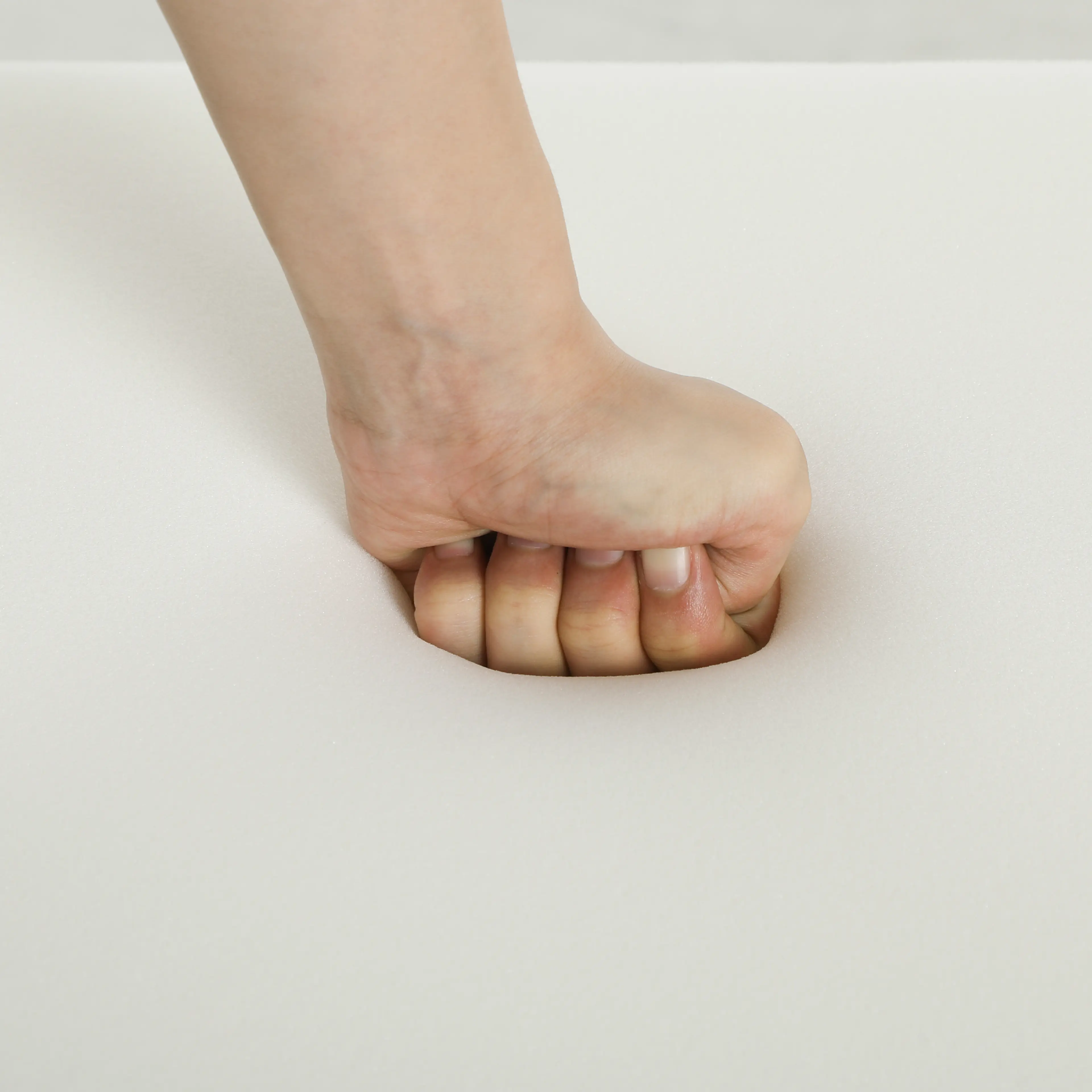 En hand trycker ner i skummet