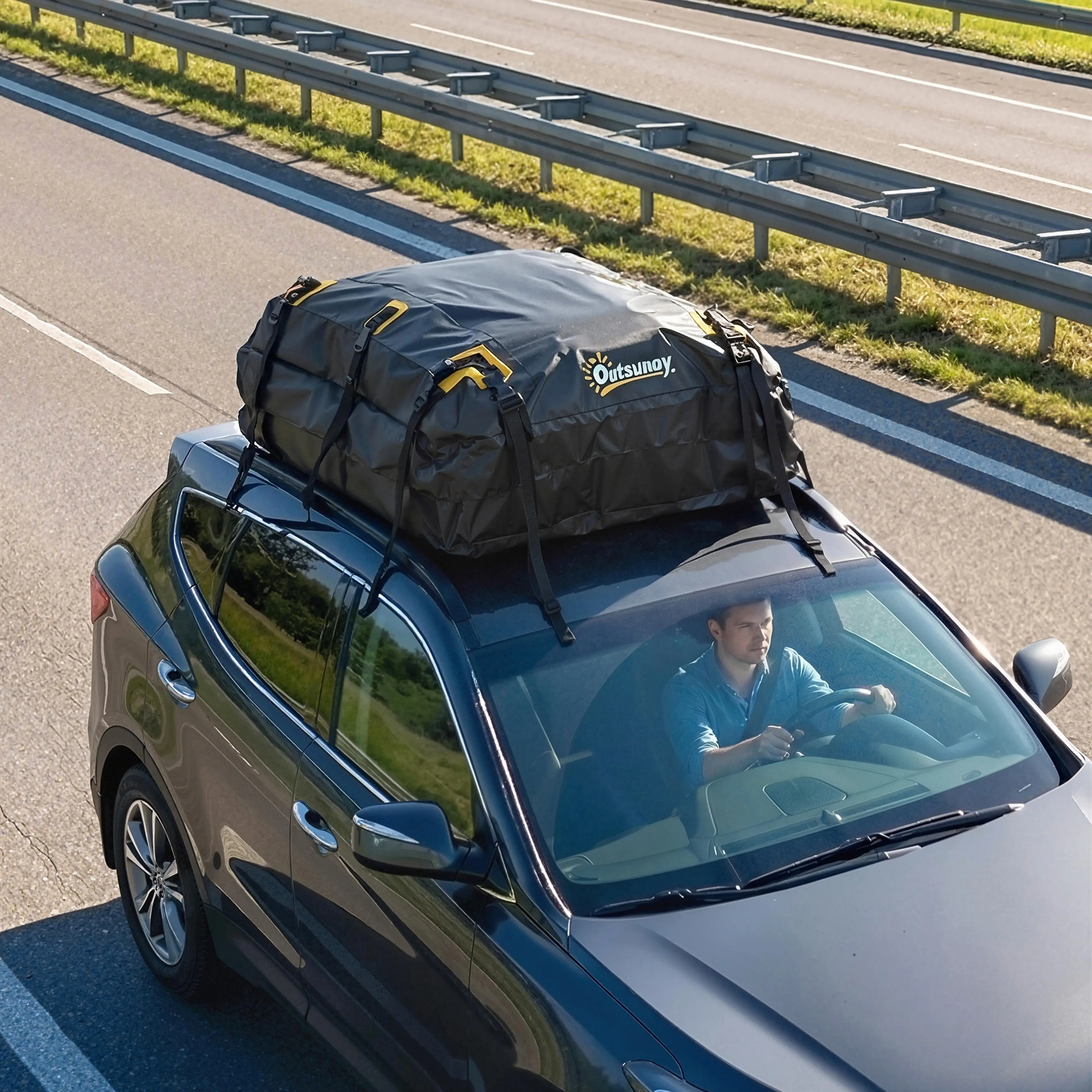 Takväska på taket av en mörk bil på motorvägen, sedd ovanifrån