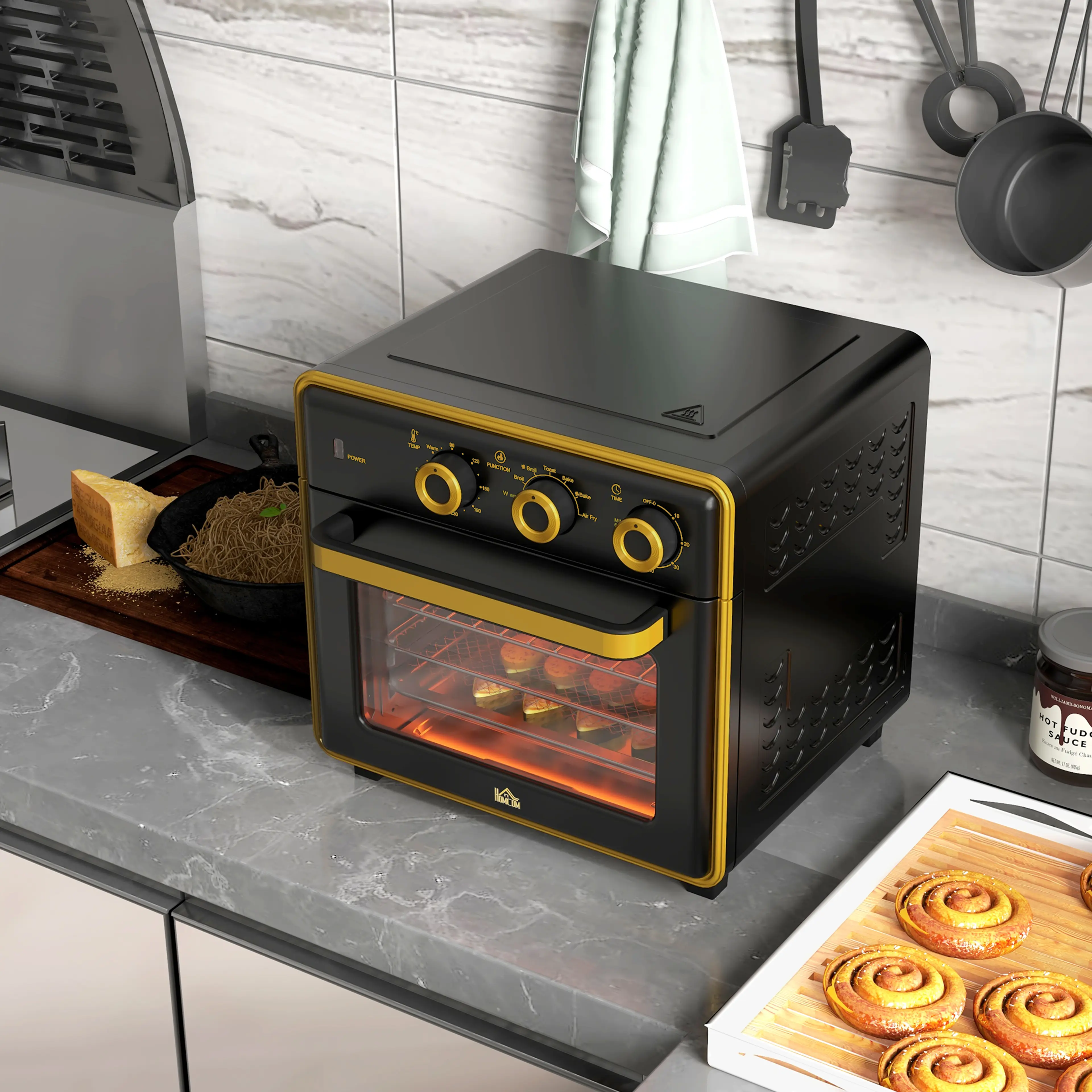 Den svarta miniugnen på en mörk köksbänk med en plåt kanelbullar framför