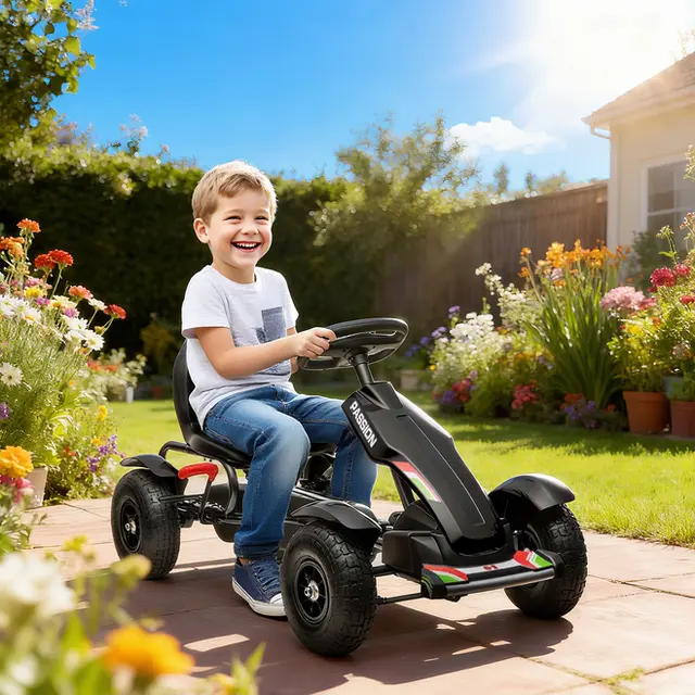 Svart trampgokart med luftdäck och handbroms, med en pojke i en trädgård