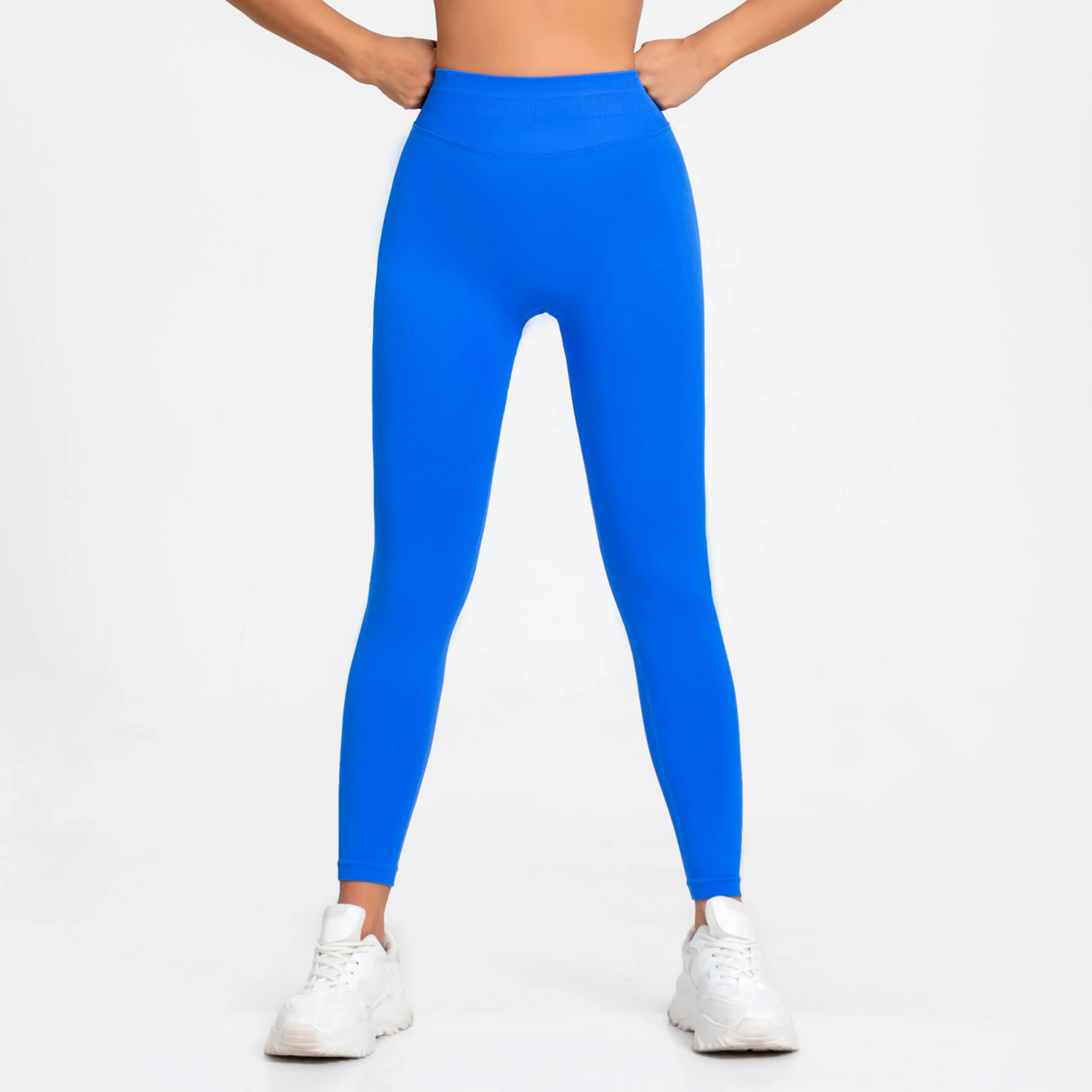 Sömlösa leggings i elektrisk blå burna av en modell, sedda framifrån och bakifrån