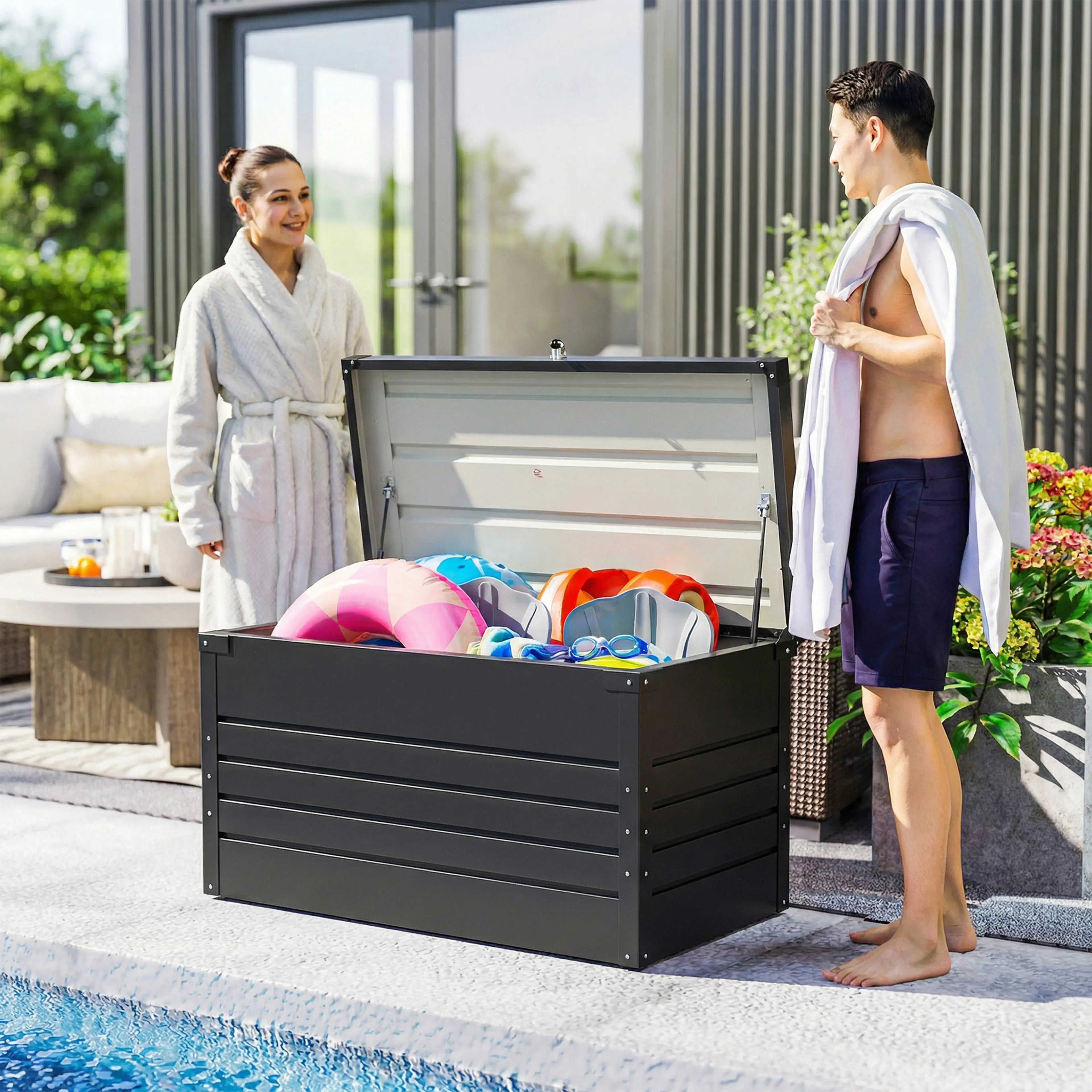 Dynboxen vid en pool med badleksaker och handdukar i