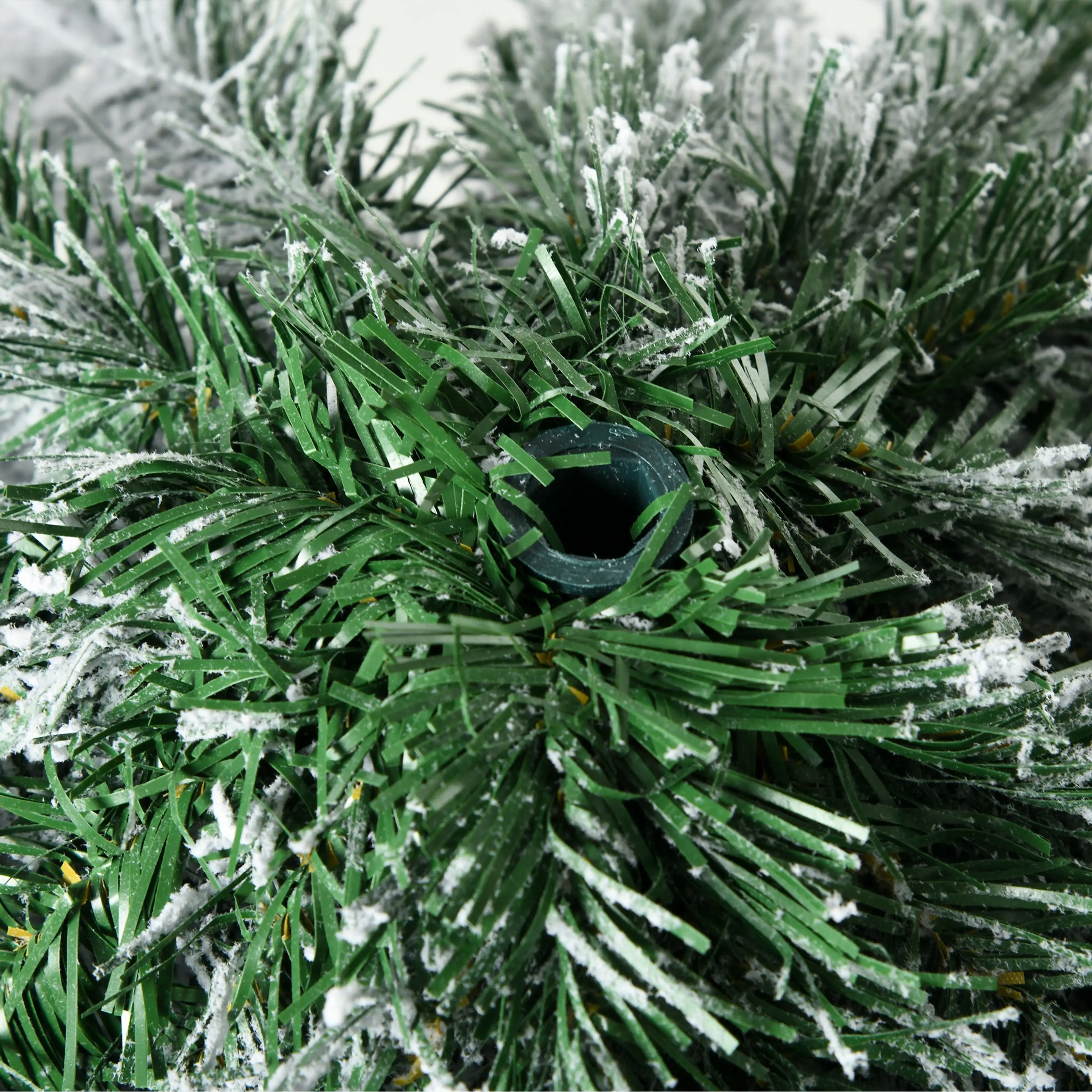 Närbild på grenverket underifrån där snön ligger på topparna