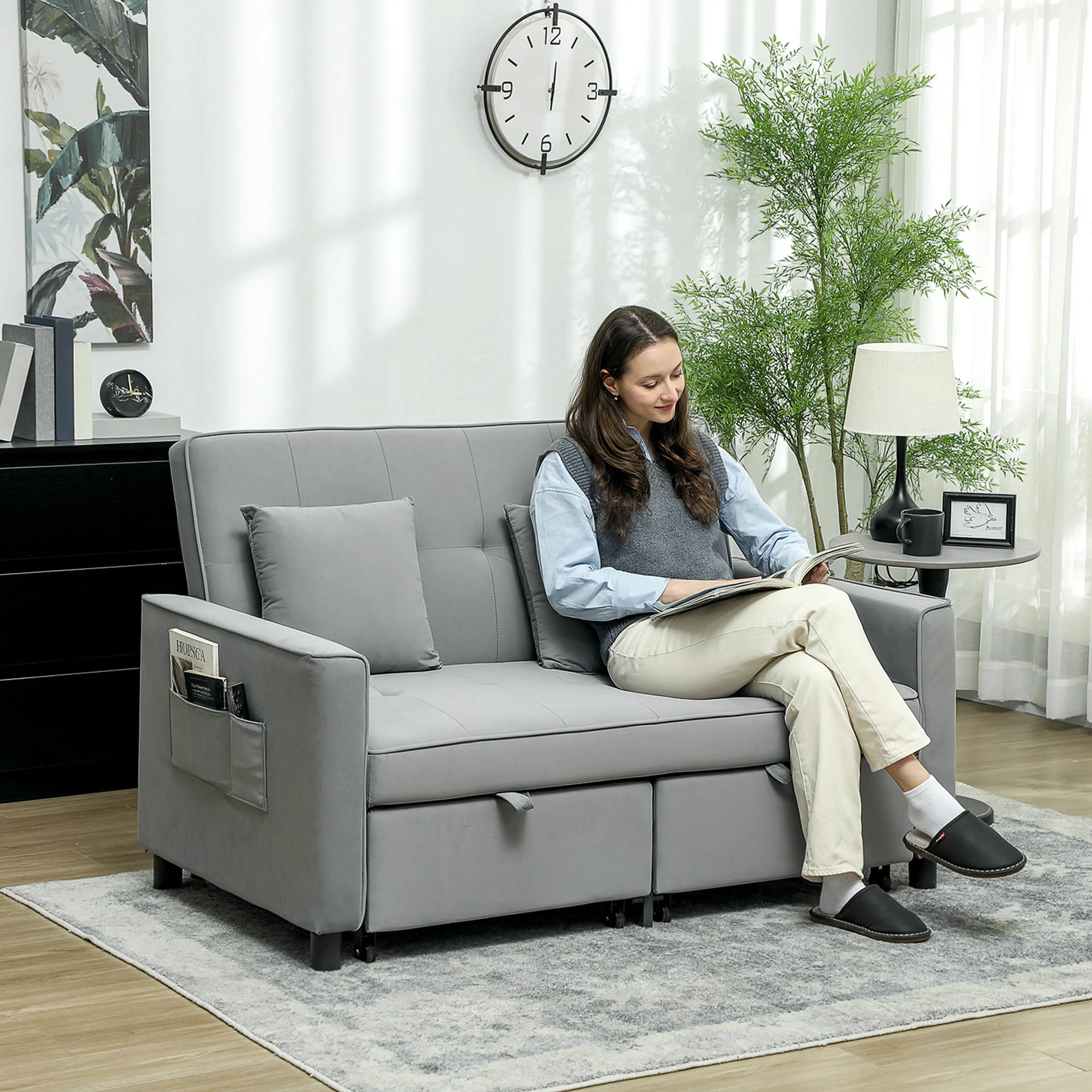 Soffan i ett vardagsrum, en person sitter och läser