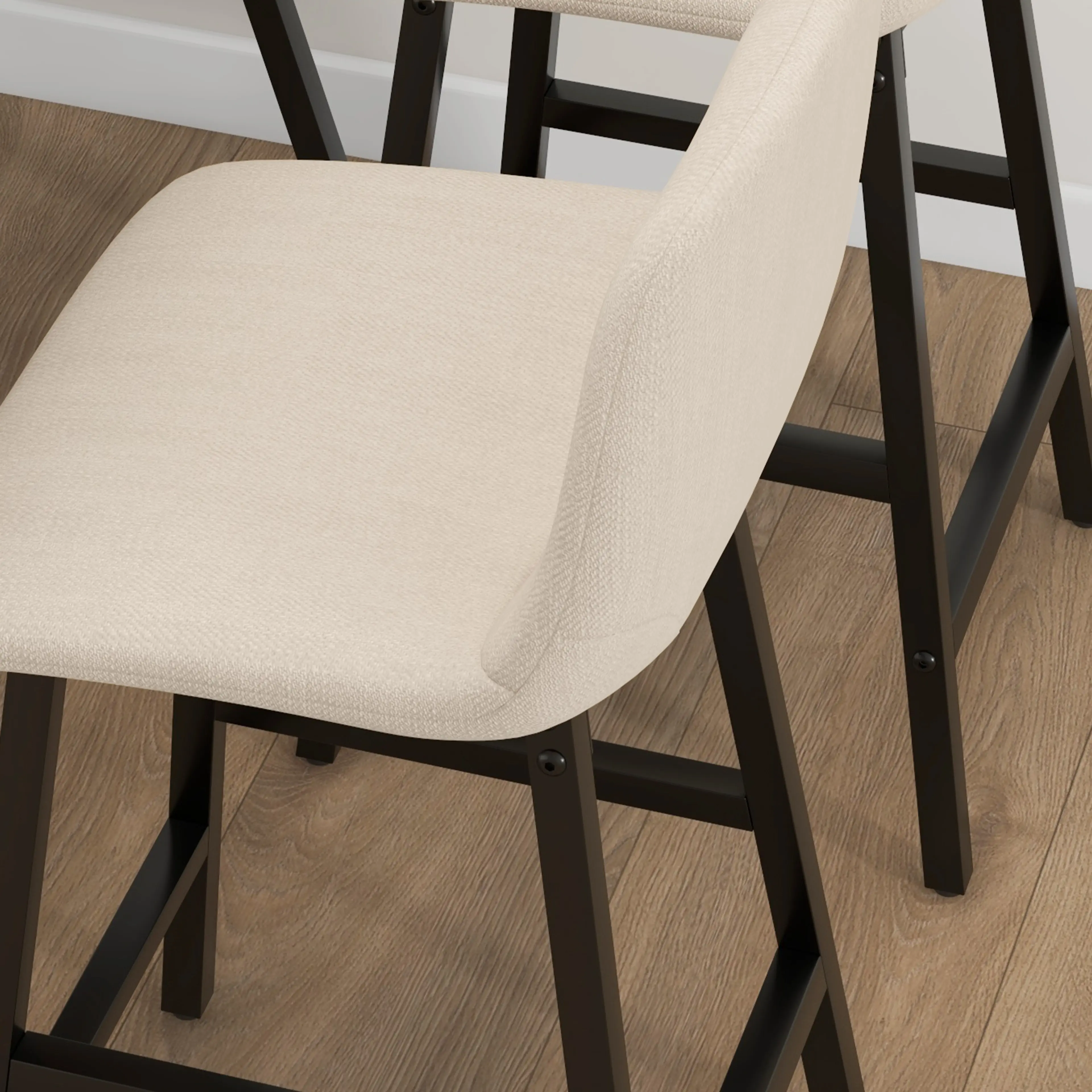 Närbild på en stoppad barstol i beige tyg med svart stålstomme