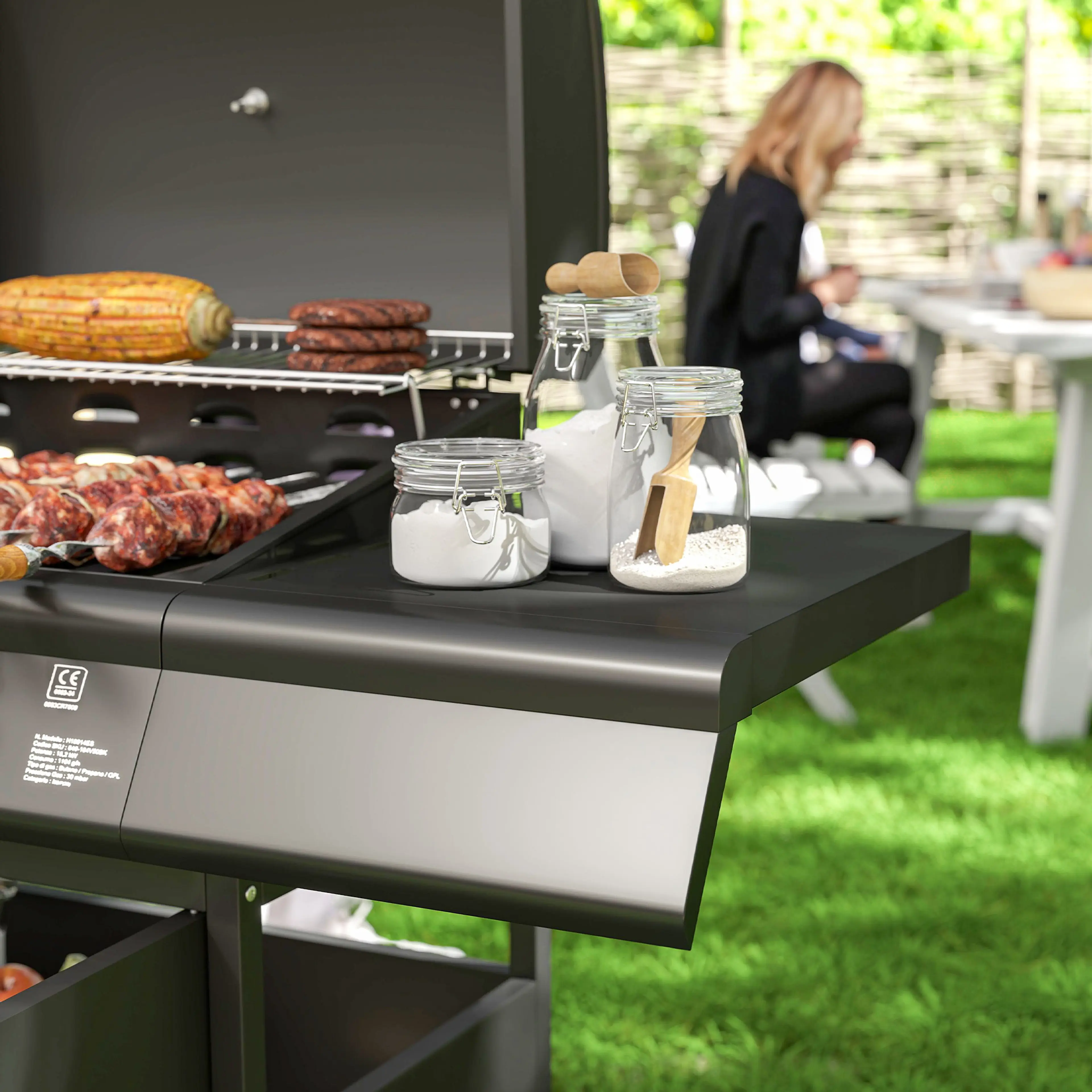 Gasolgrillen på en uteplats med tallrikar och mat på sidobordet