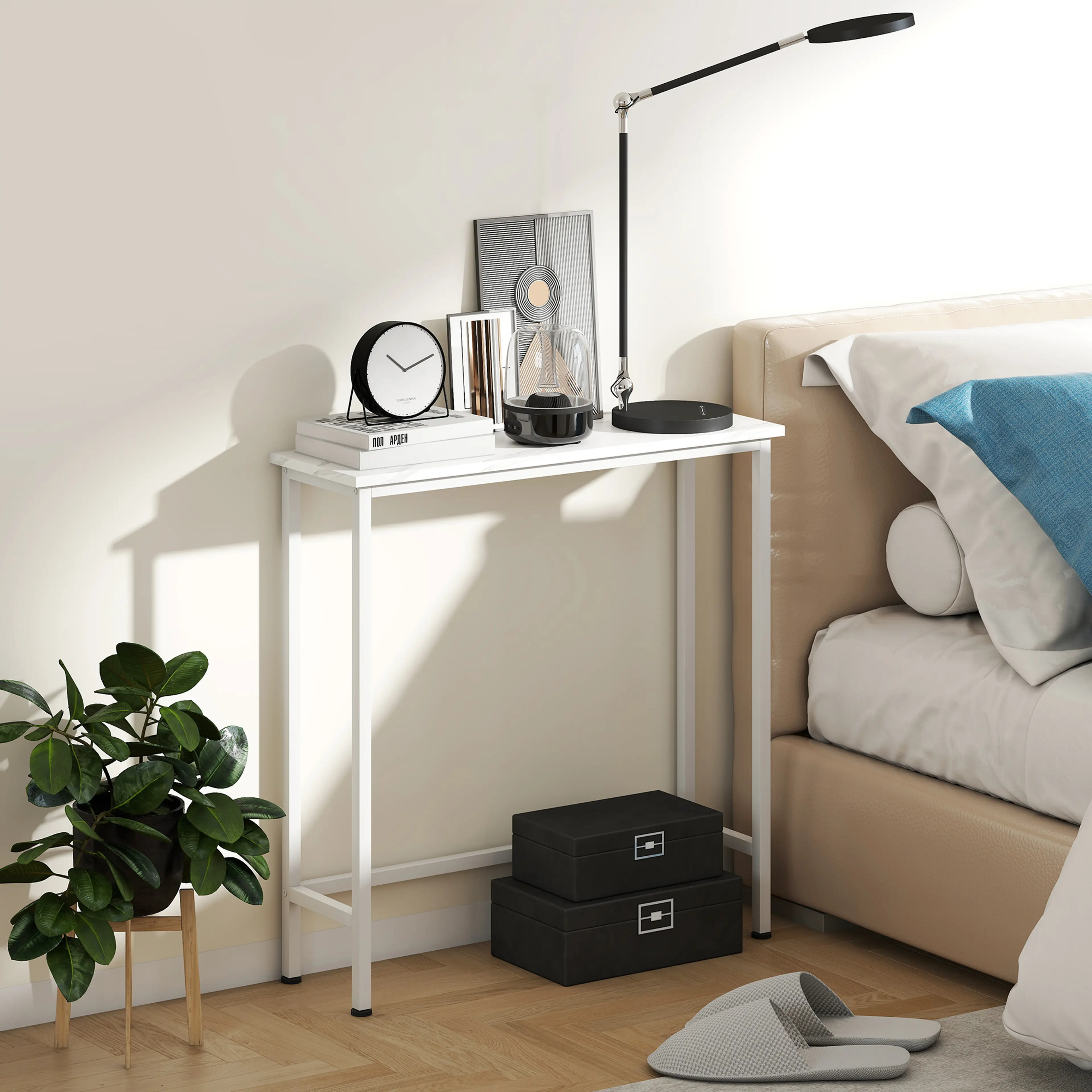 Konsolbordet bredvid en säng med bordslampa, klocka och böcker
