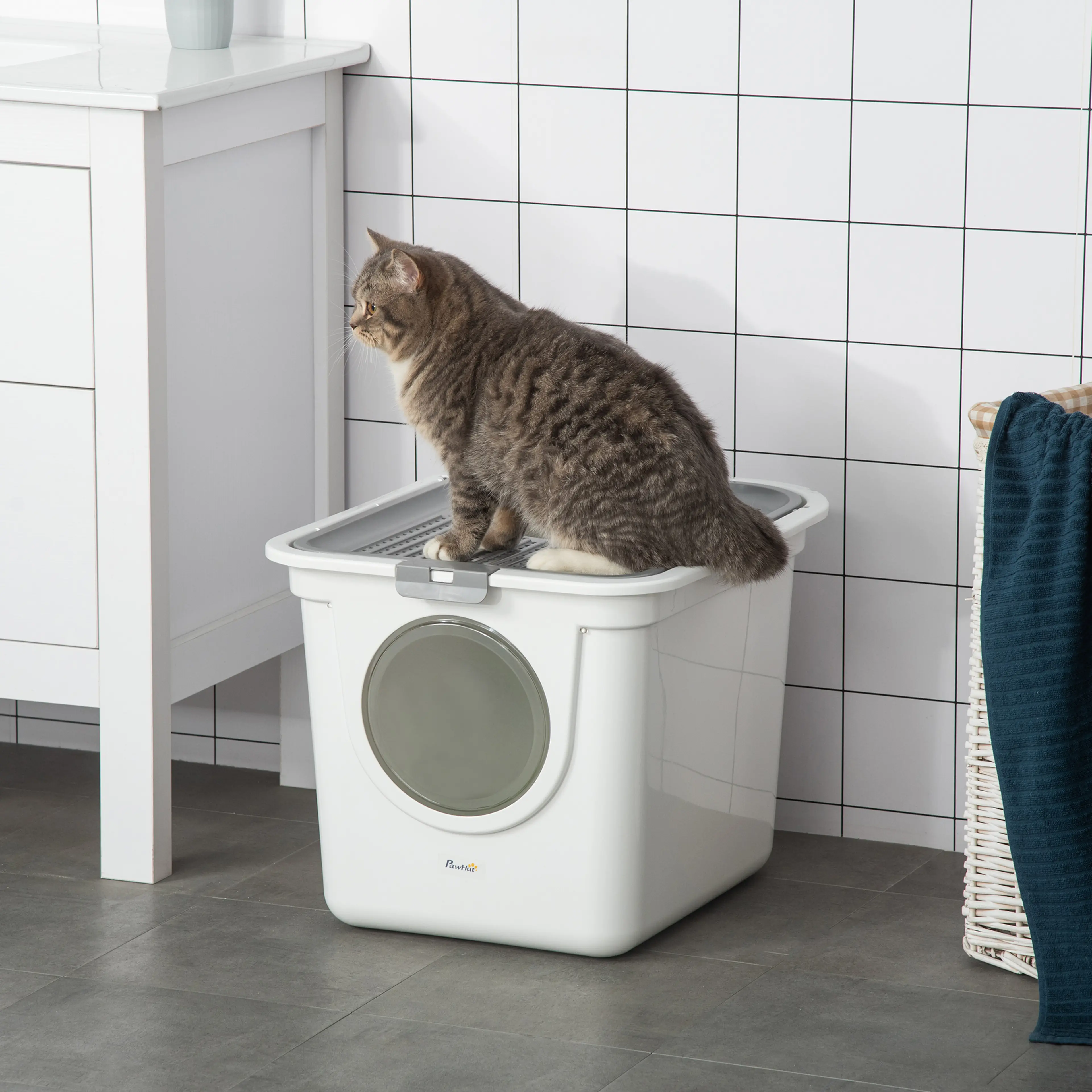 Kattlådan med grått lock och rund dörr i ett badrum