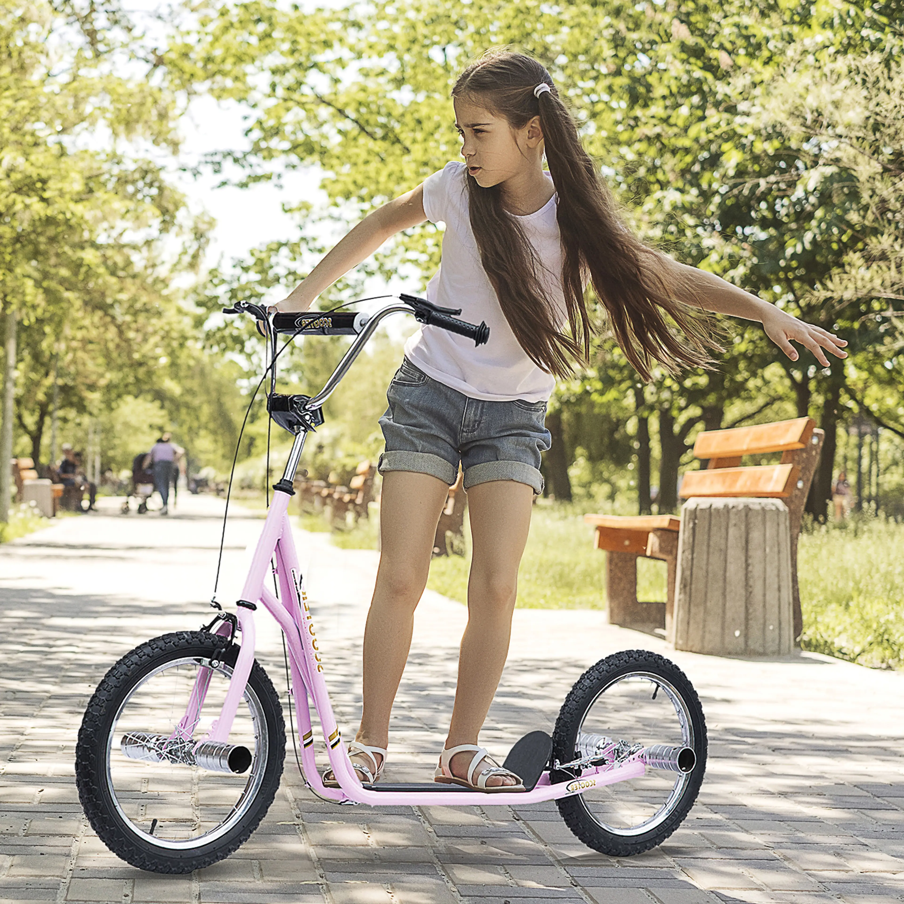 Flicka åker rosa sparkcykel på en asfalterad parkväg