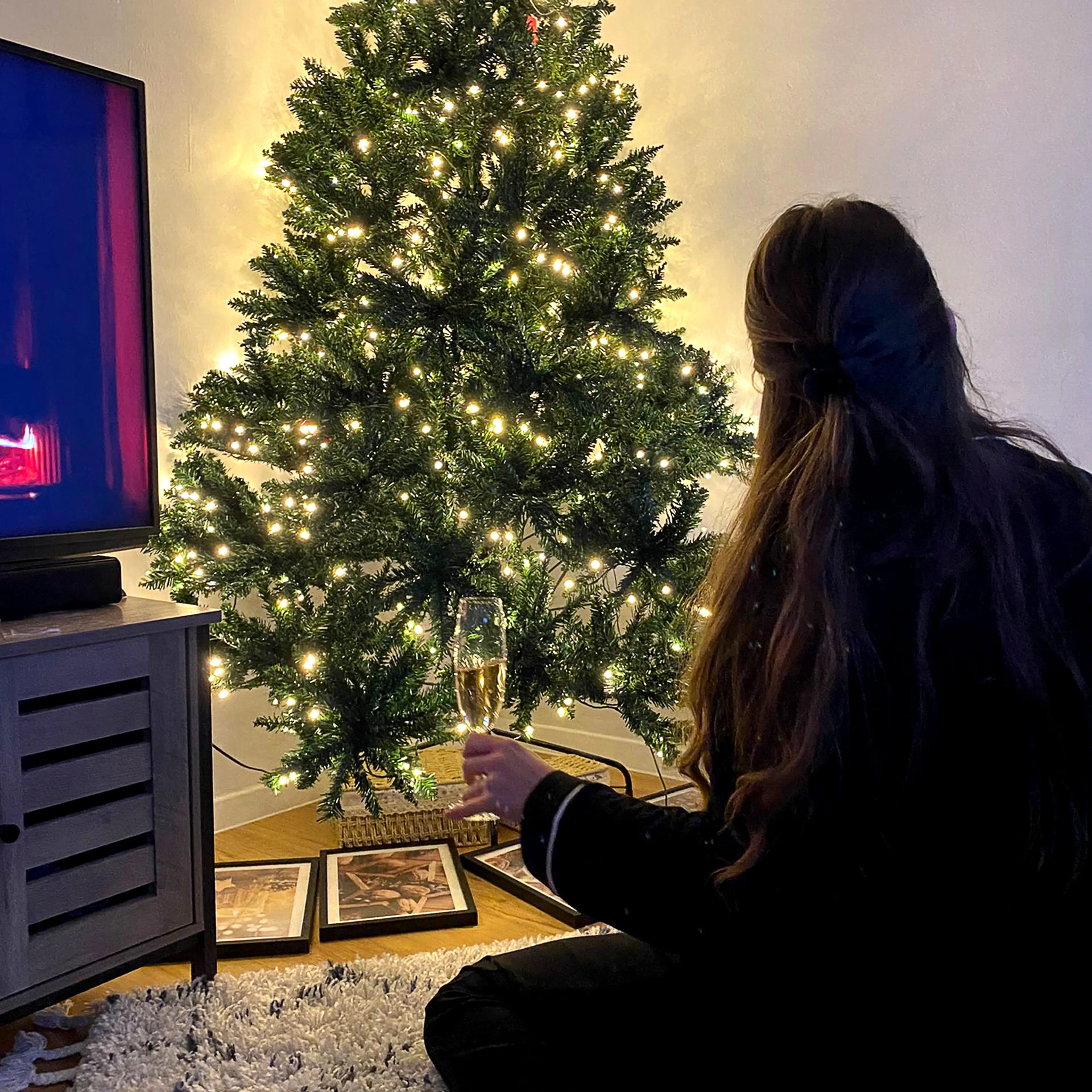 Julgranen tänd i ett mörkt rum där ljuspunkterna ligger på olika djup
