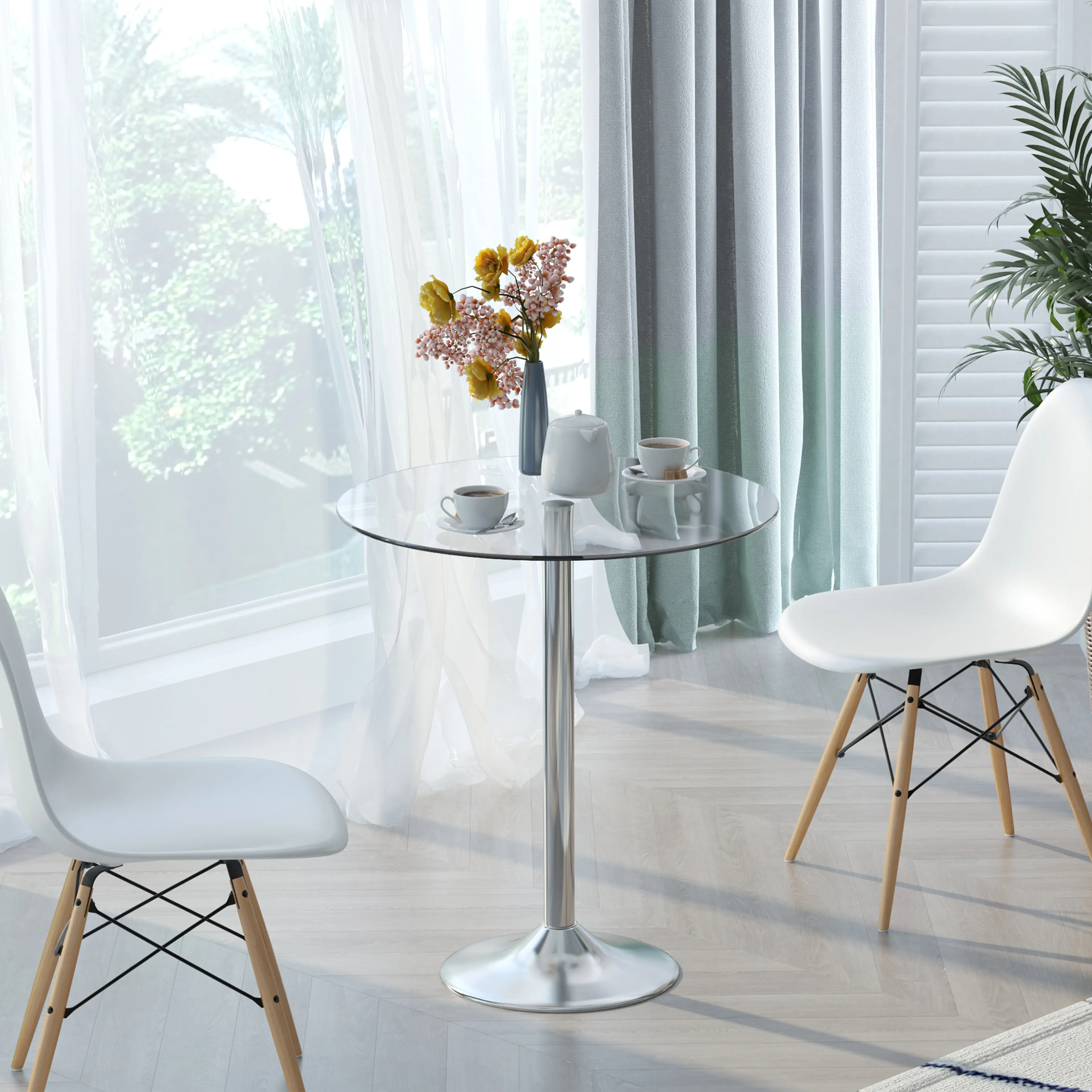 Glasbordet med två vita stolar, blommor och en tekanna vid ett fönster