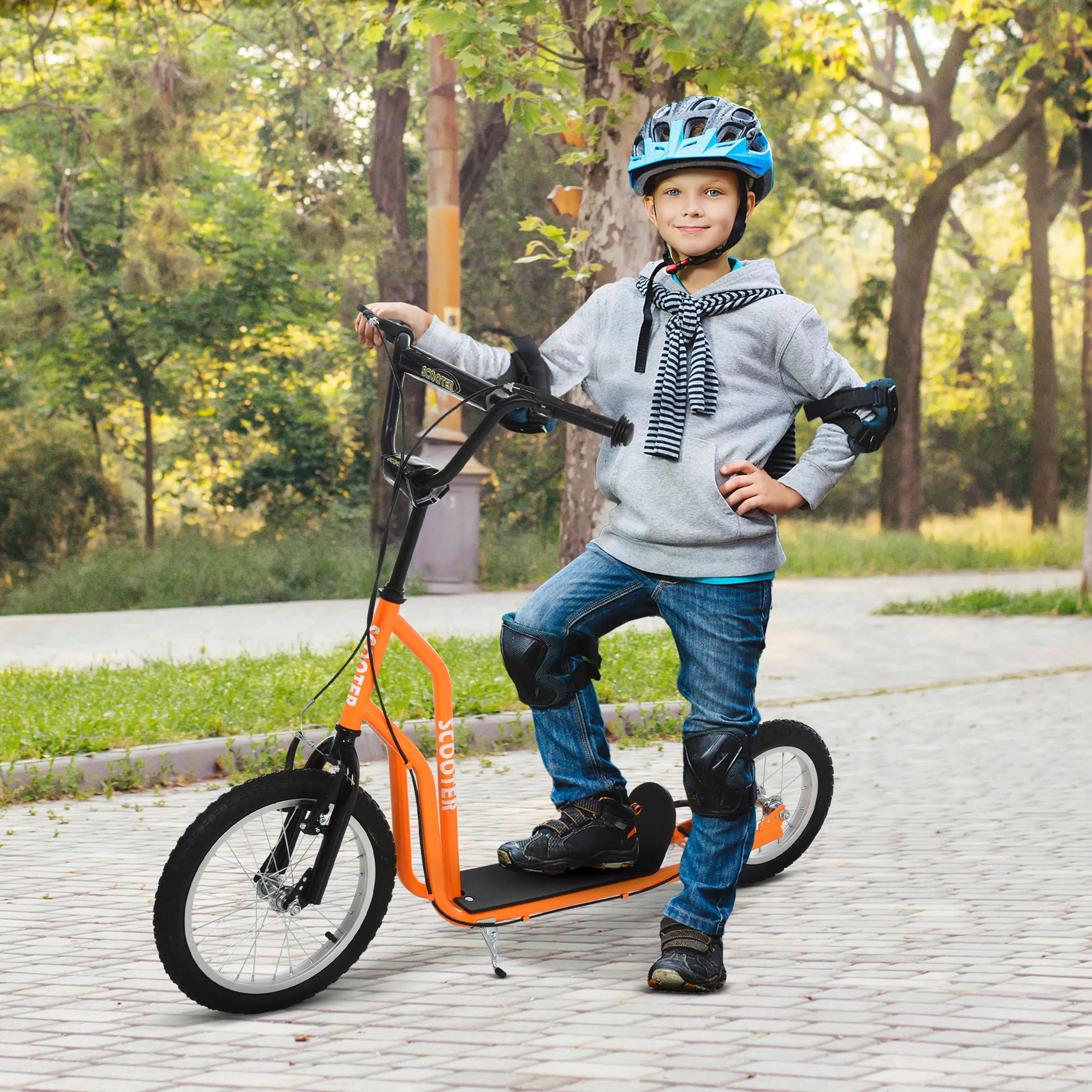 Pojke åker orange sparkcykel med stort framhjul på en gångväg