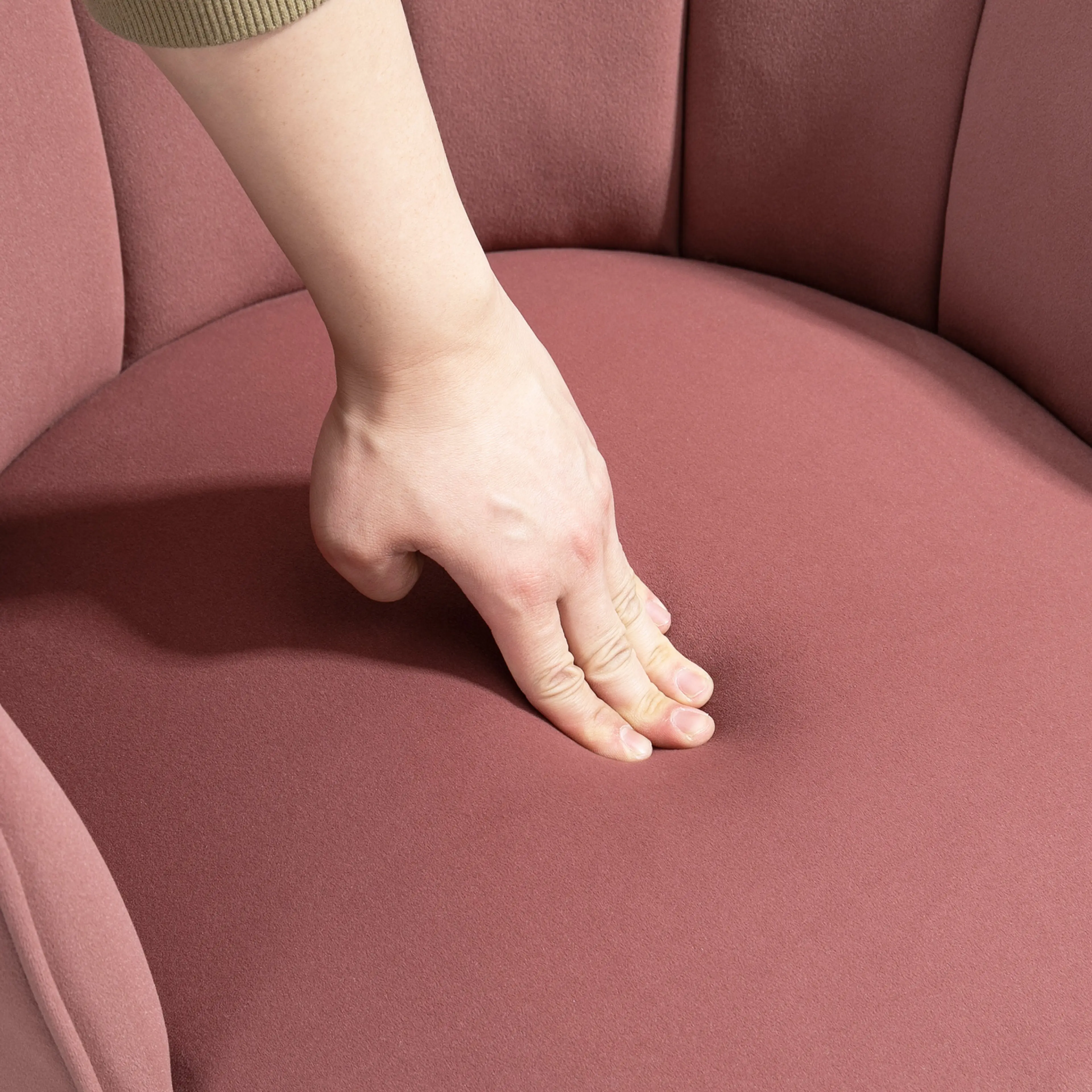 Hand som trycker ned i den rosa sammetssitsen