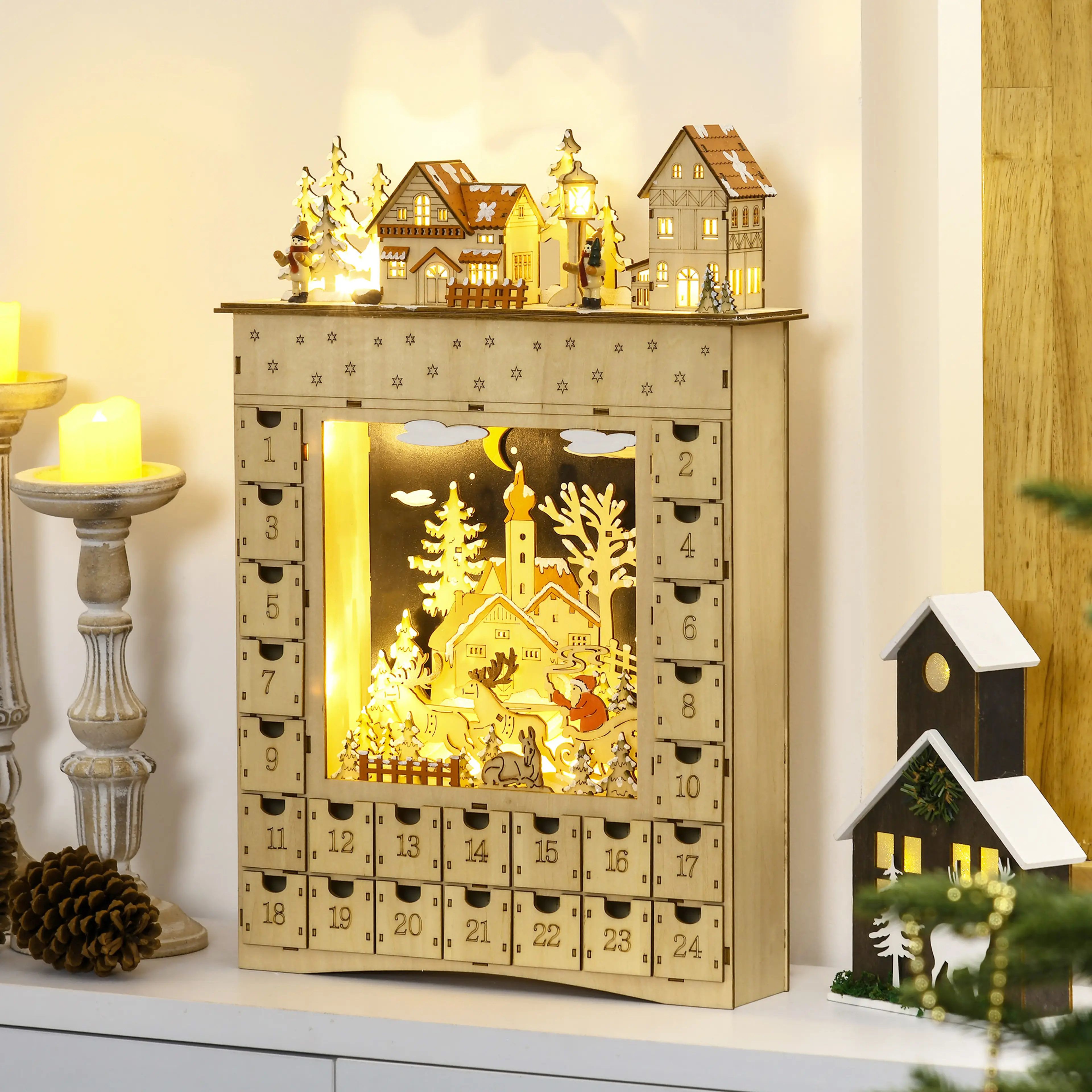Adventskalendern tänd på en byrå bredvid ljus och kottar