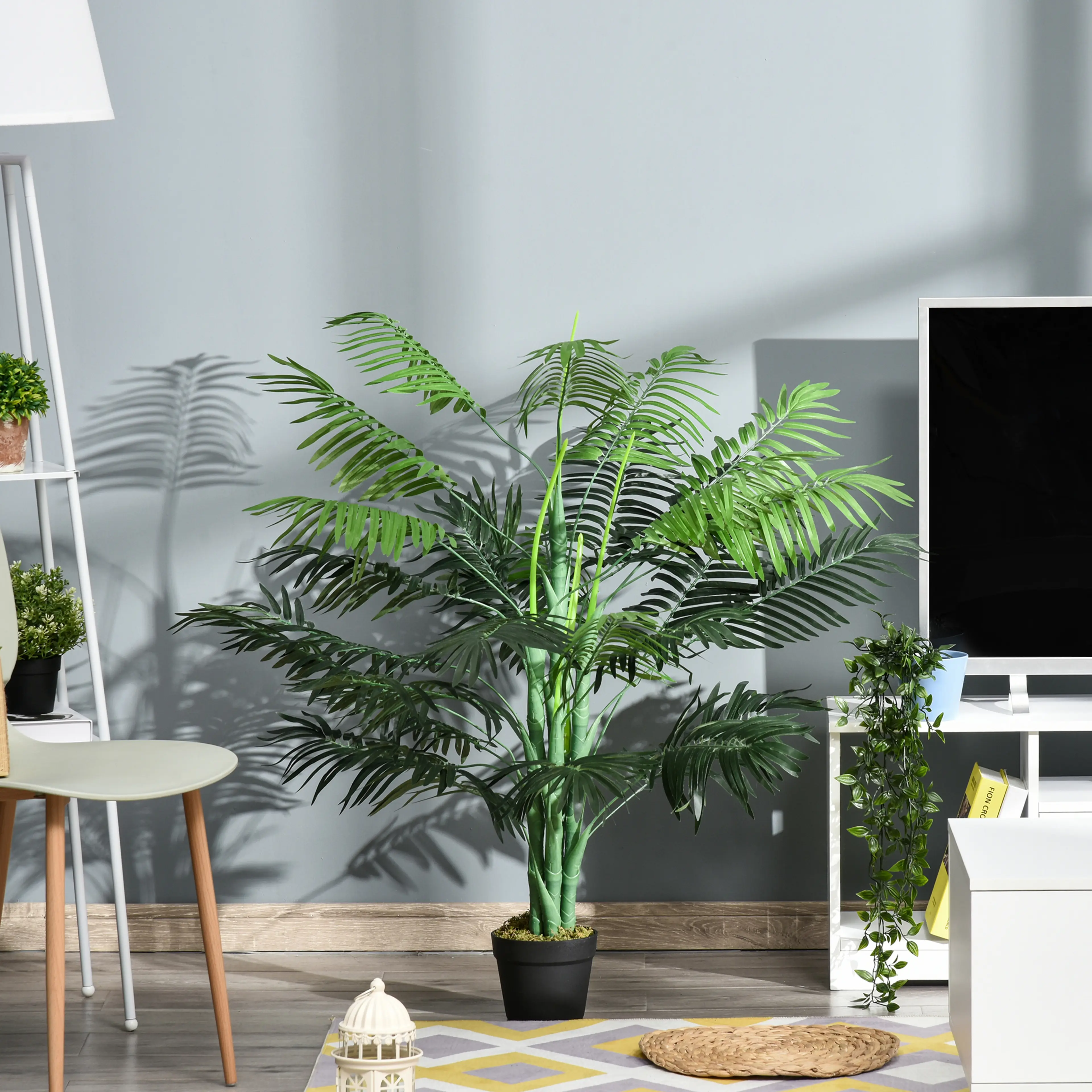 Palmen i ett vardagsrum bredvid en vit tv-bänk