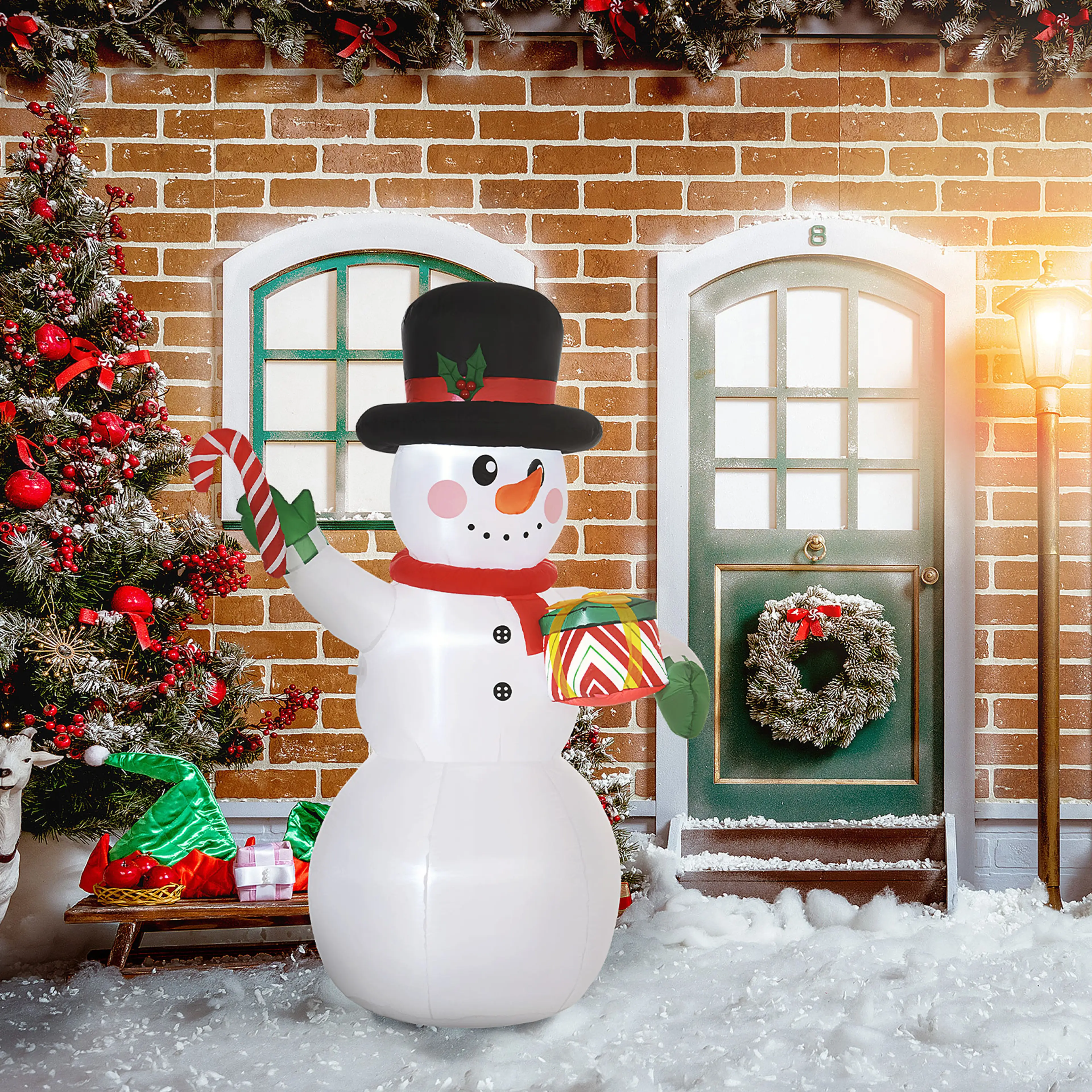 Snögubben framför ett tegelhus med julgran och krans