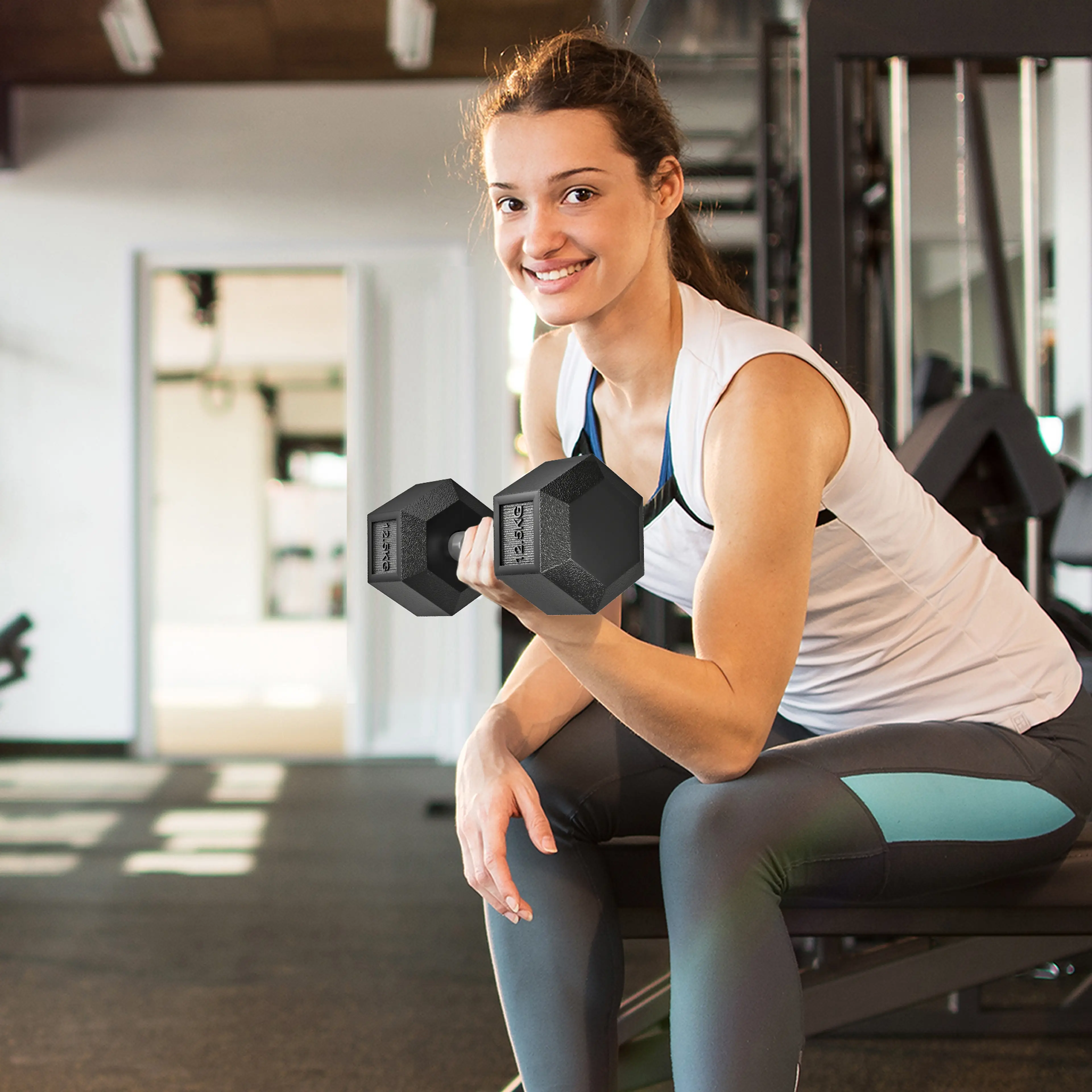 Kvinna gör bicepscurl med en hexhantel