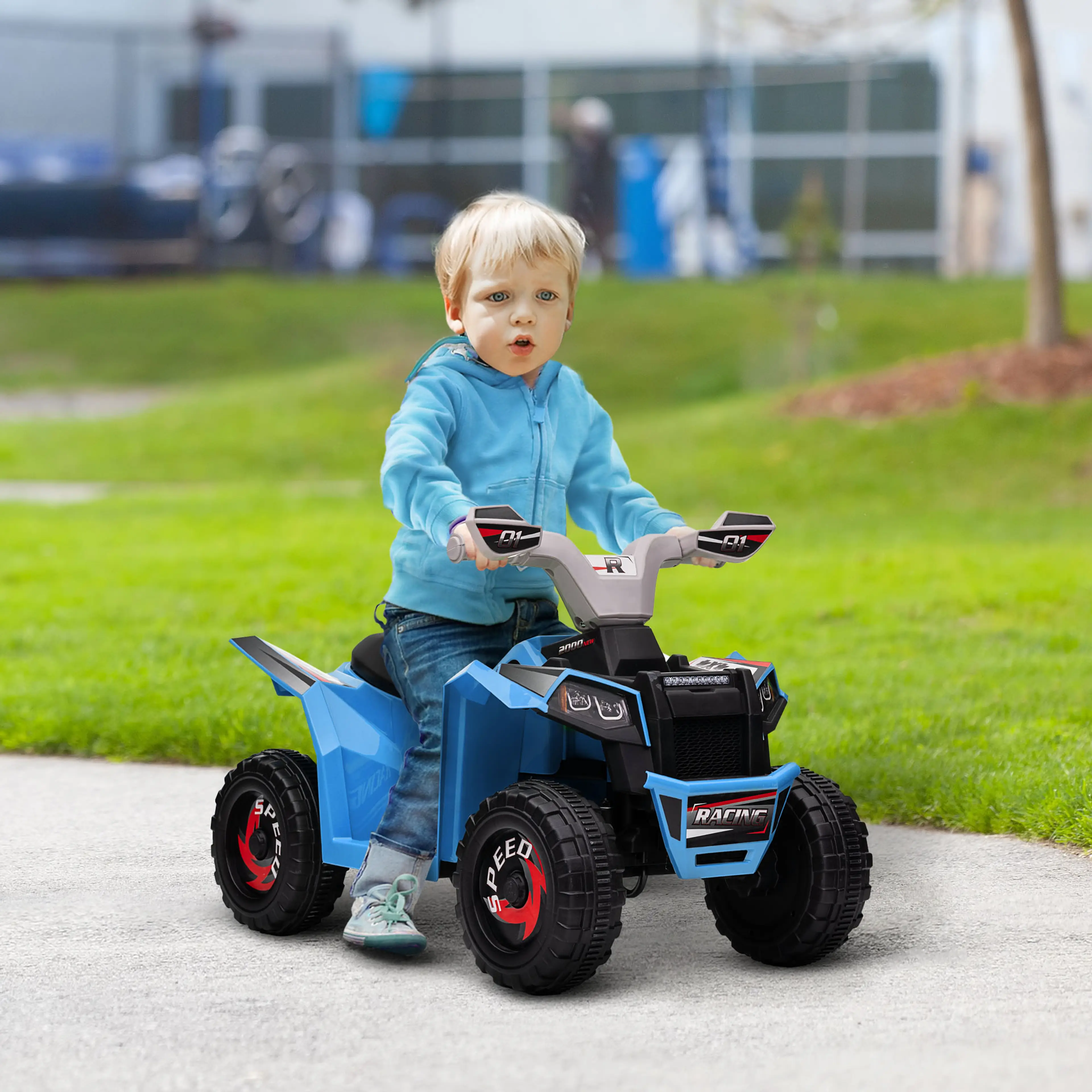 Ett litet barn kör fyrhjulingen på en väg i en park