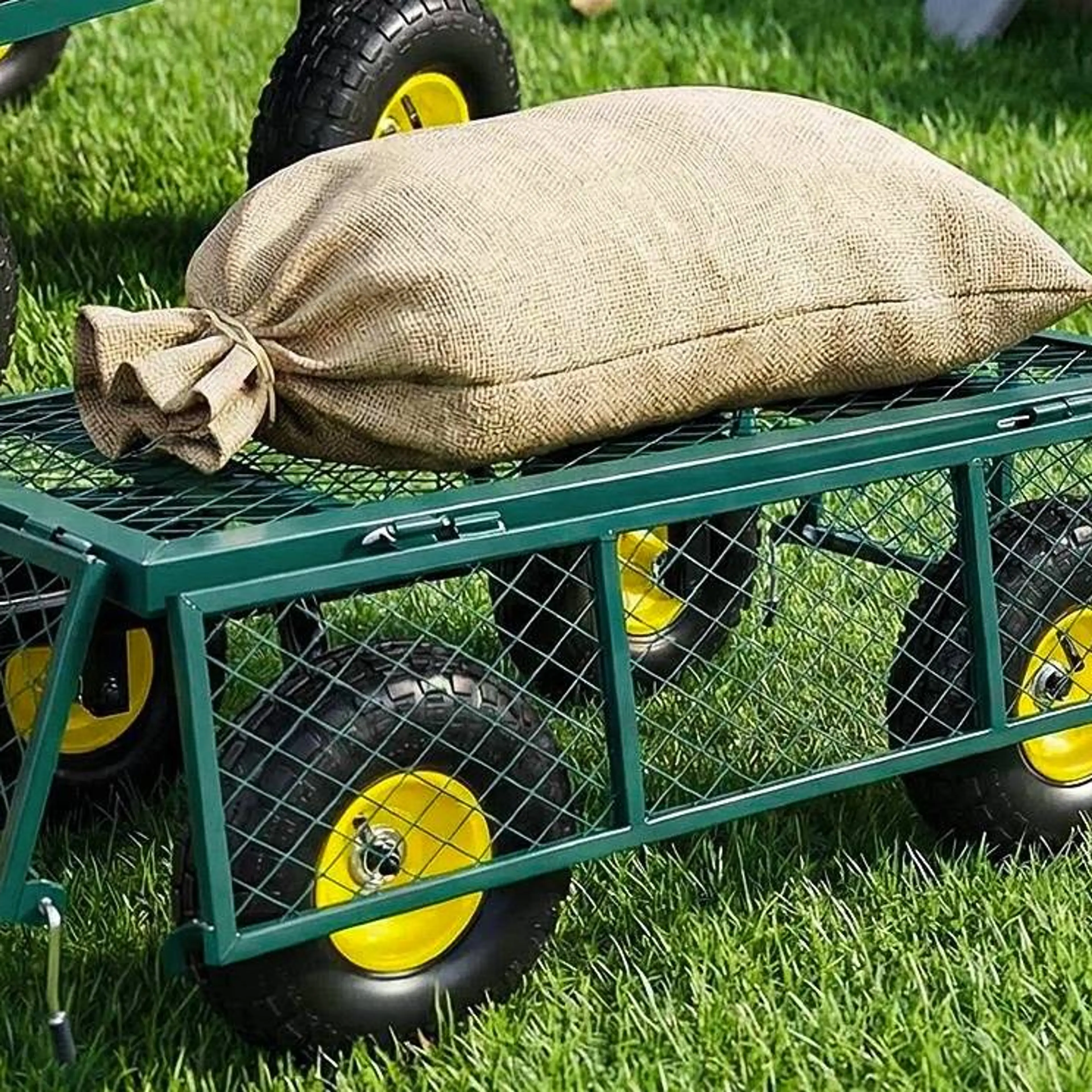 Transportvagnen med sidorna avtagna, som plant flak med en jutesäck på gräsmattan