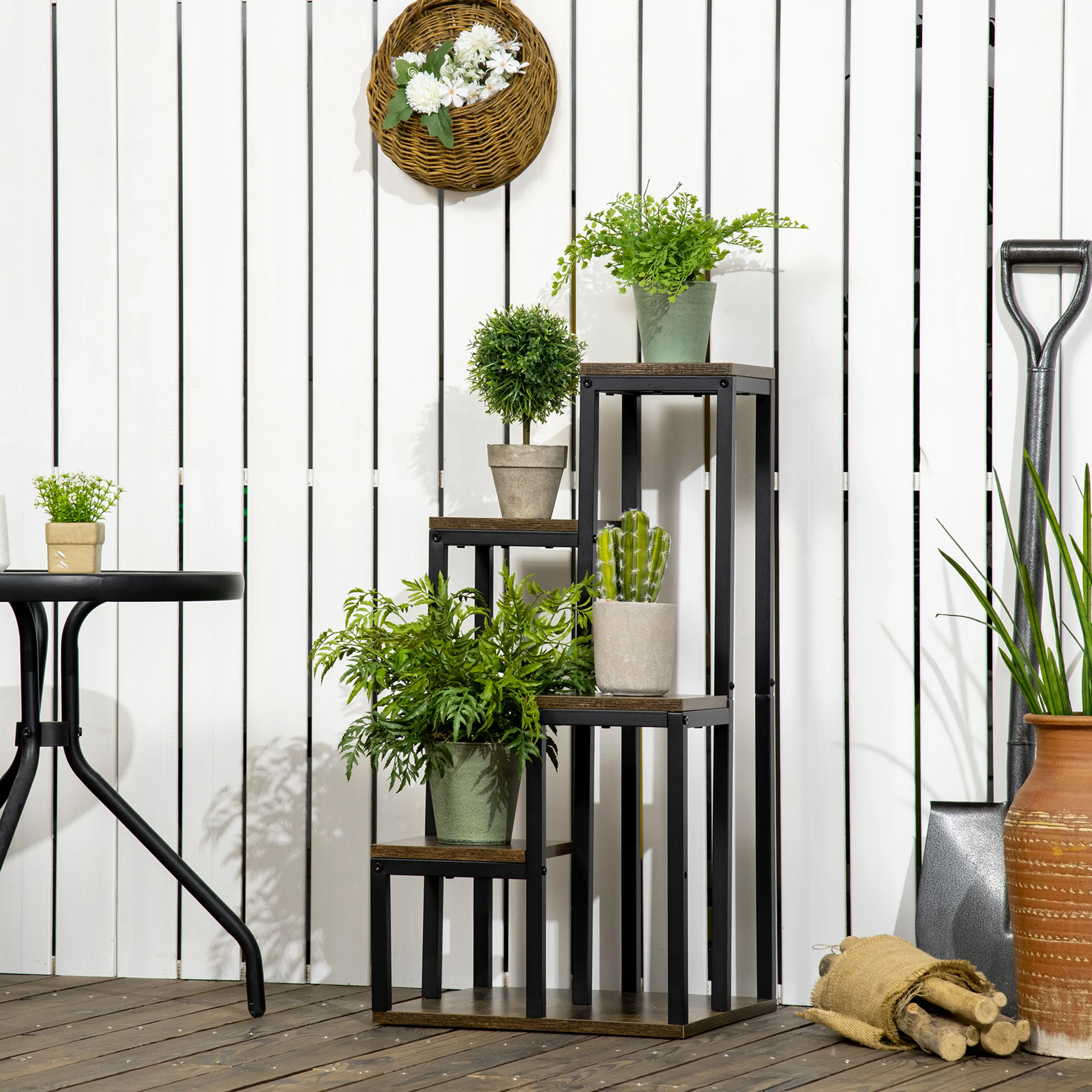 Blomstället med växter bredvid ett bord på en uteplats
