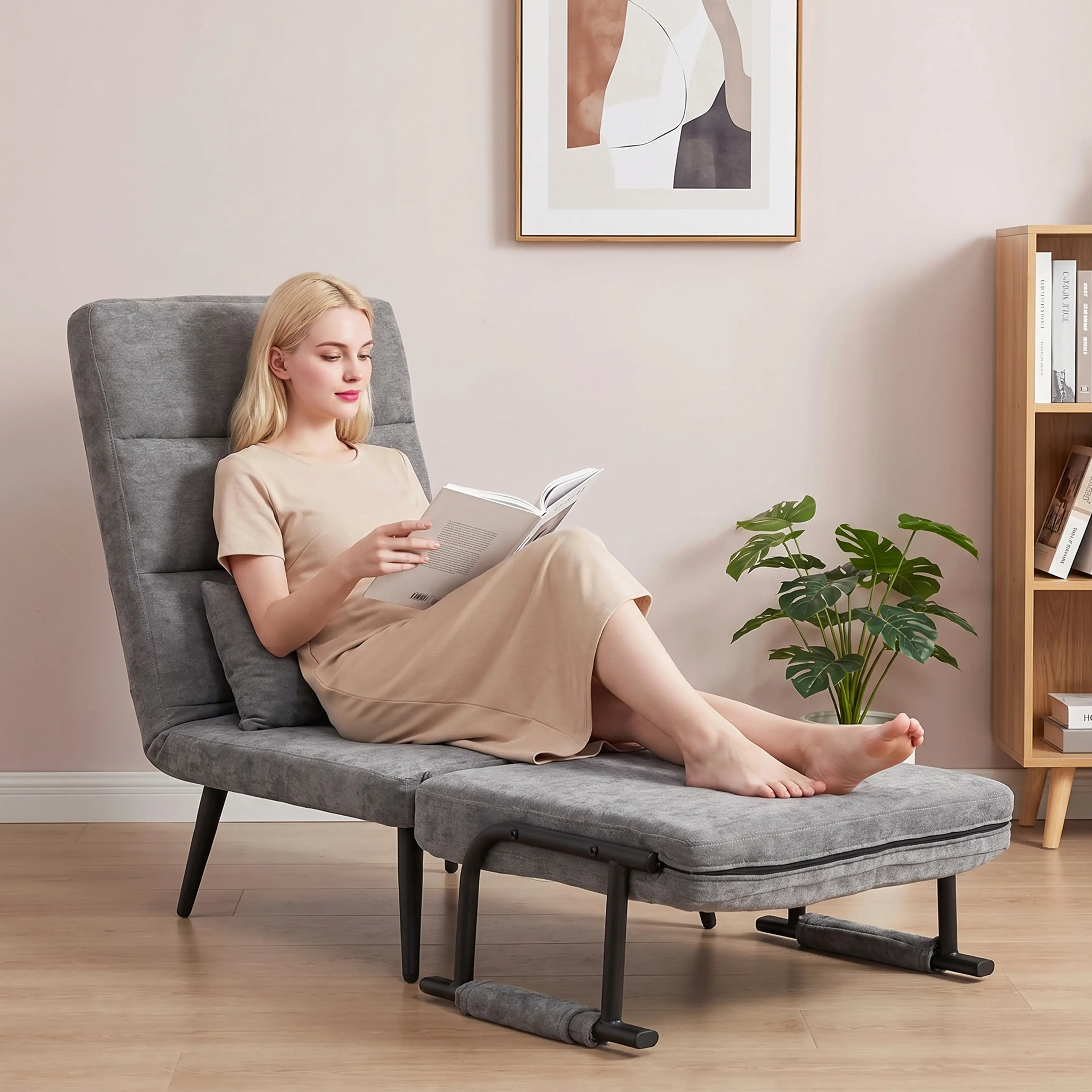 En person sitter och läser med benen utsträckta i fåtöljen