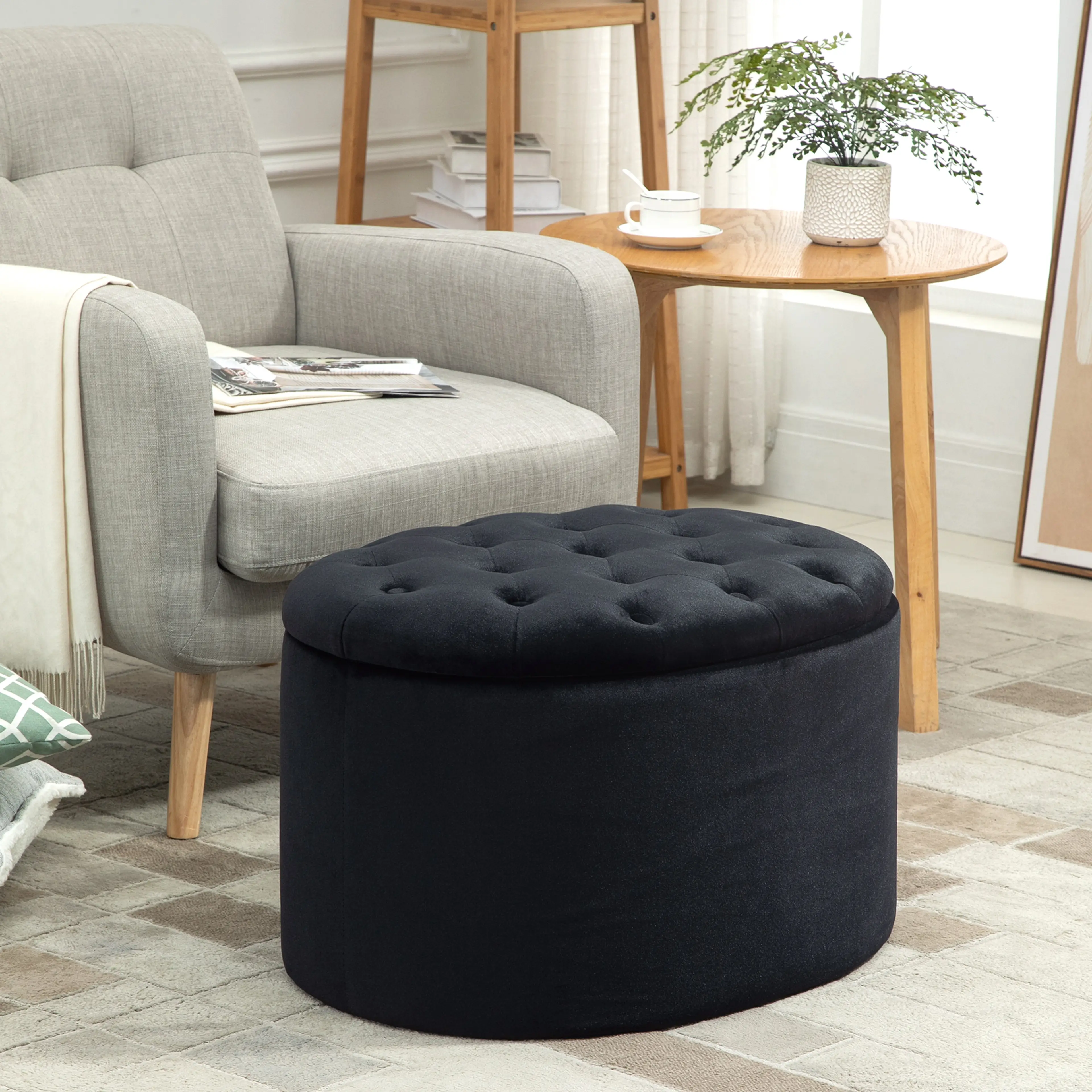 Den ovala puffen framför en beige fåtölj i ett ljust vardagsrum