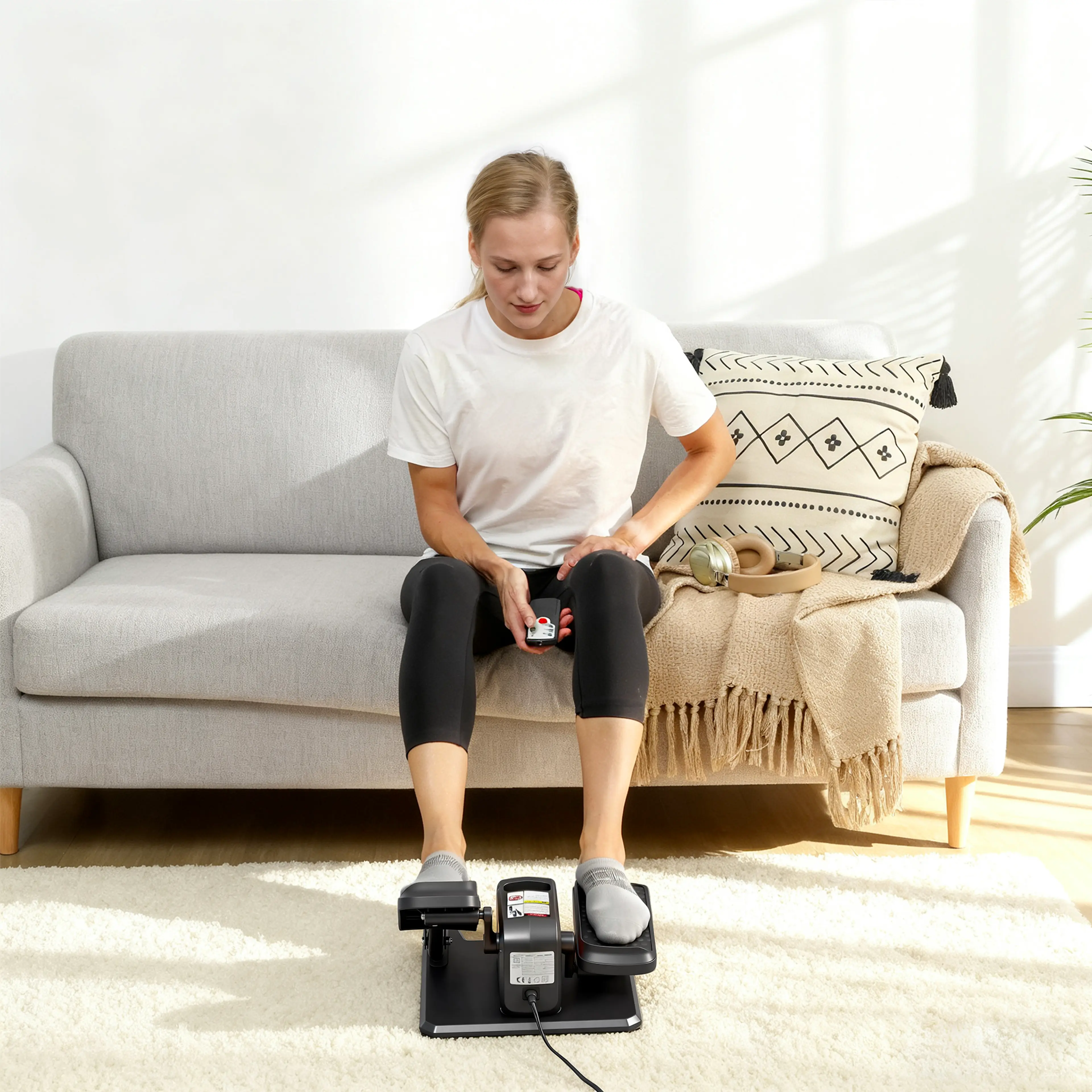 Fötterna på de halkfria pedalerna framför soffan