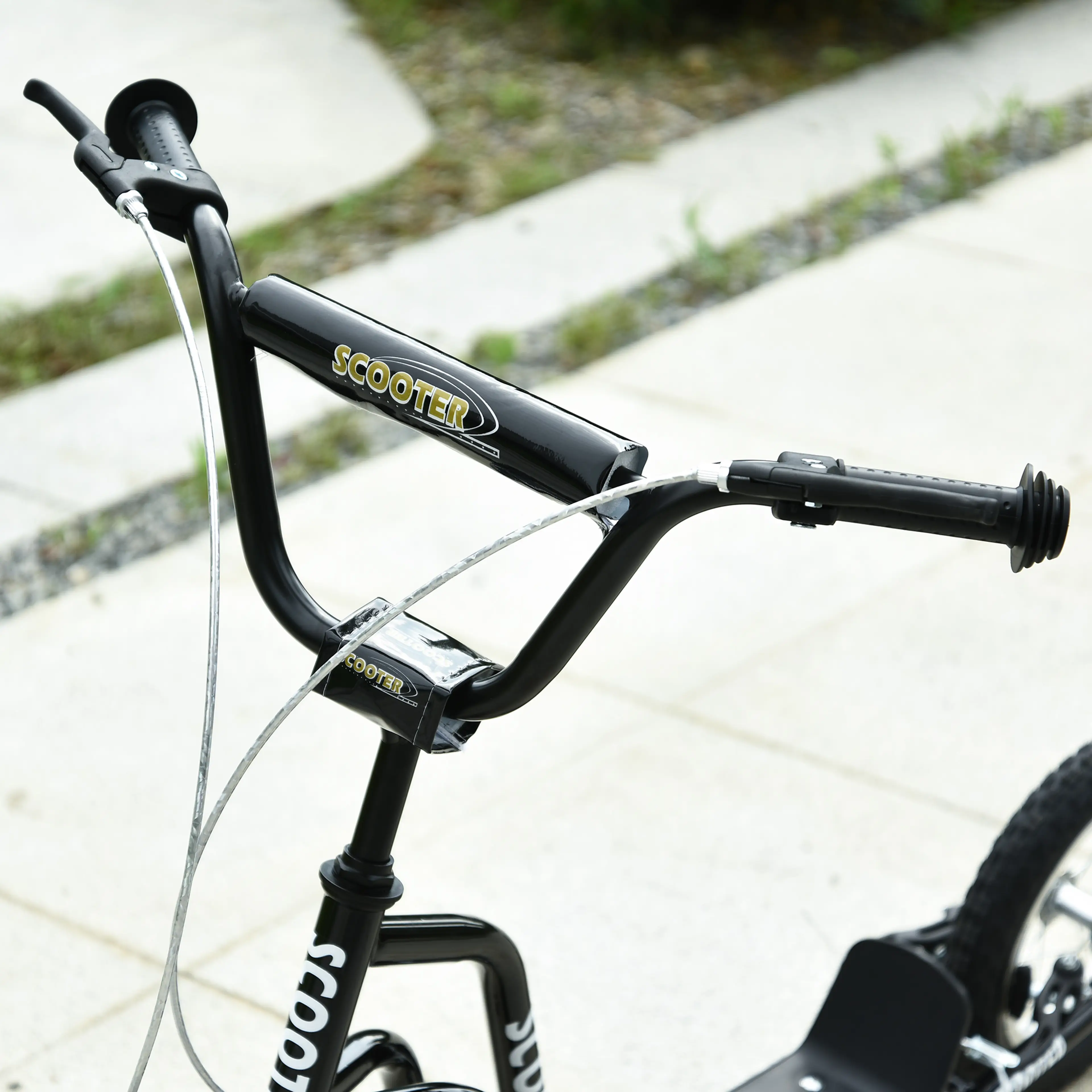 Närbild på det breda styret med bromshandtag på svart sparkcykel