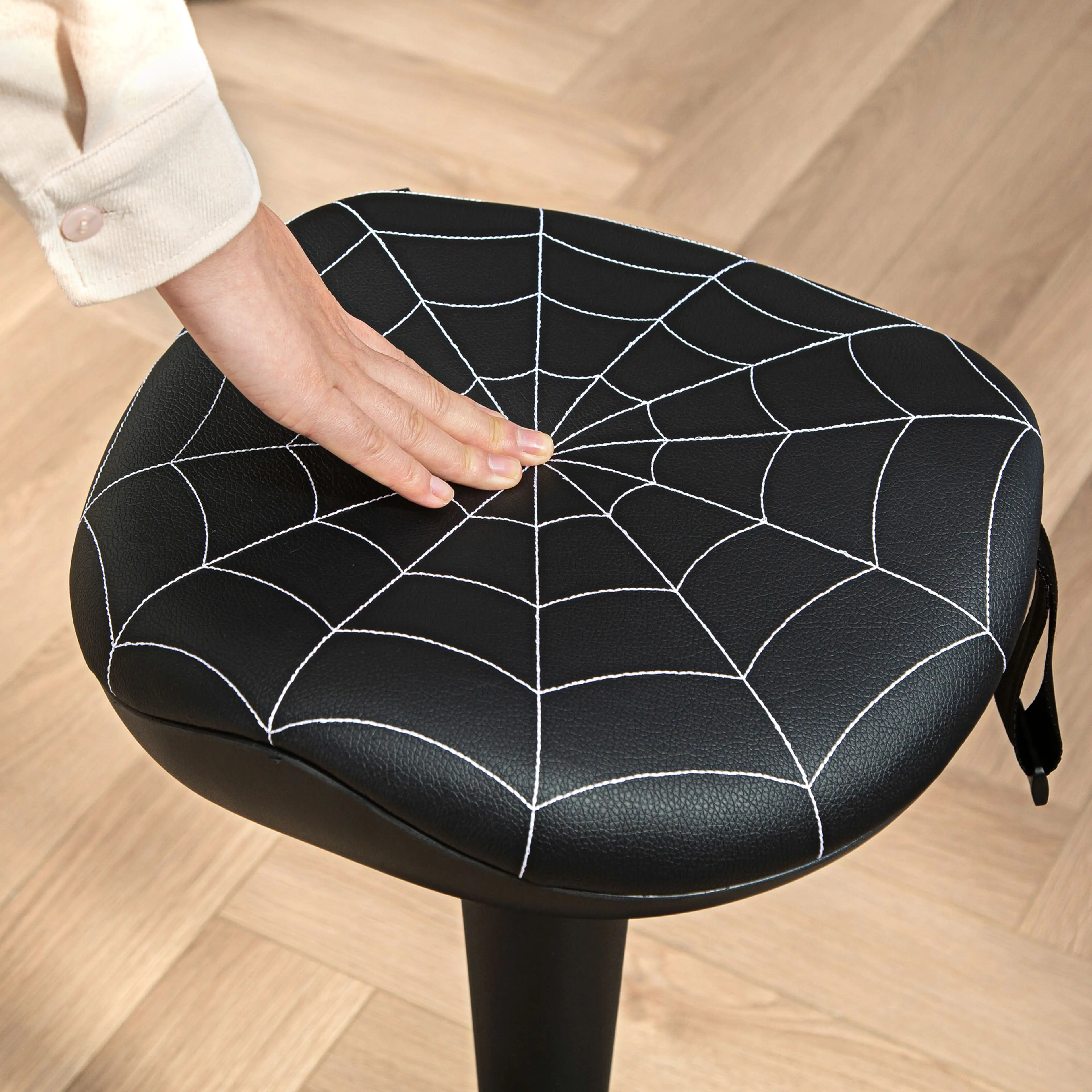 Närbild på sitsen med spindelnätsmönster