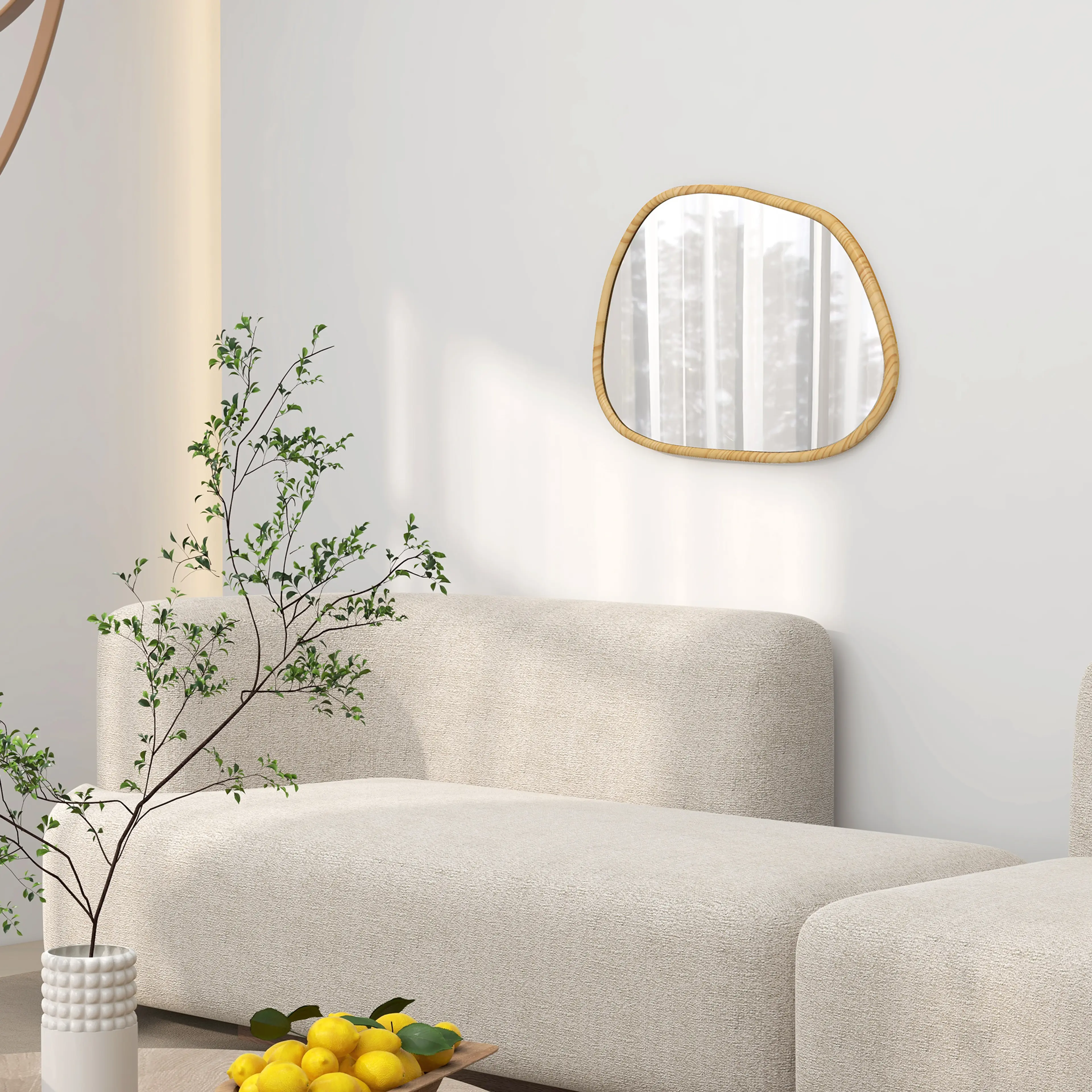 Spegeln på en ljus vägg ovanför en beige soffa