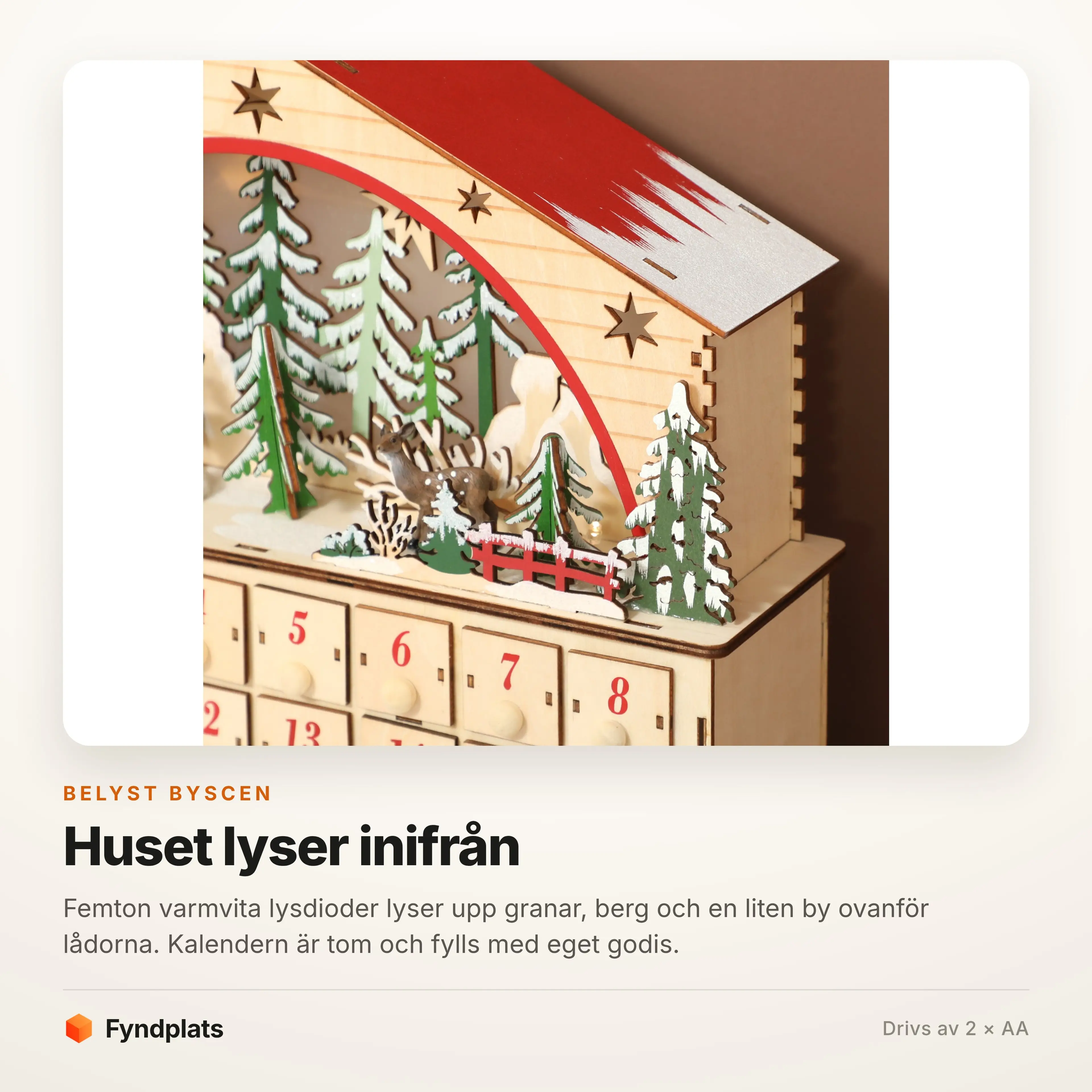 Närbild på den belysta byscenen med granar och berg