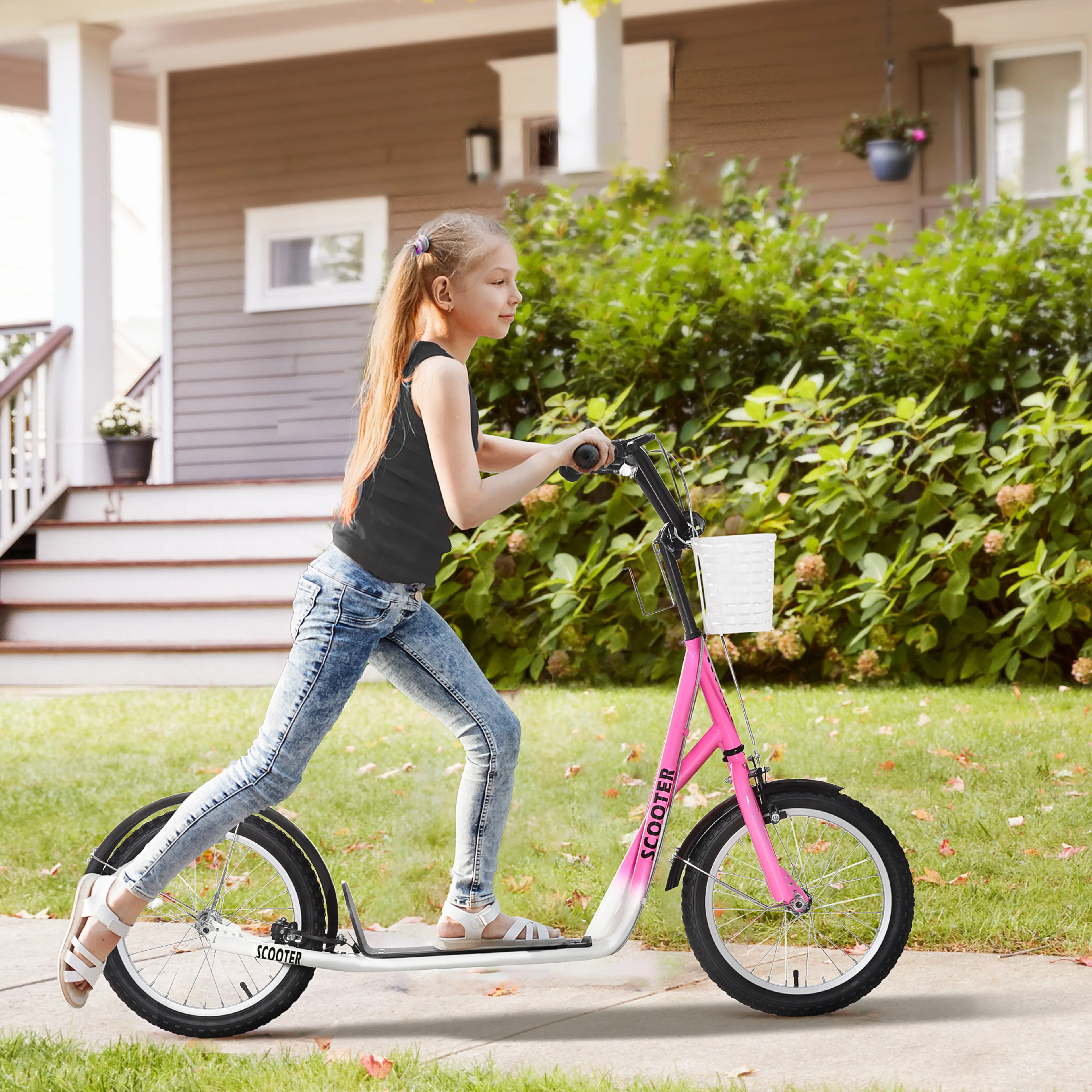 Flicka i hjälm åker rosa sparkcykel med vit korg framför ett hus