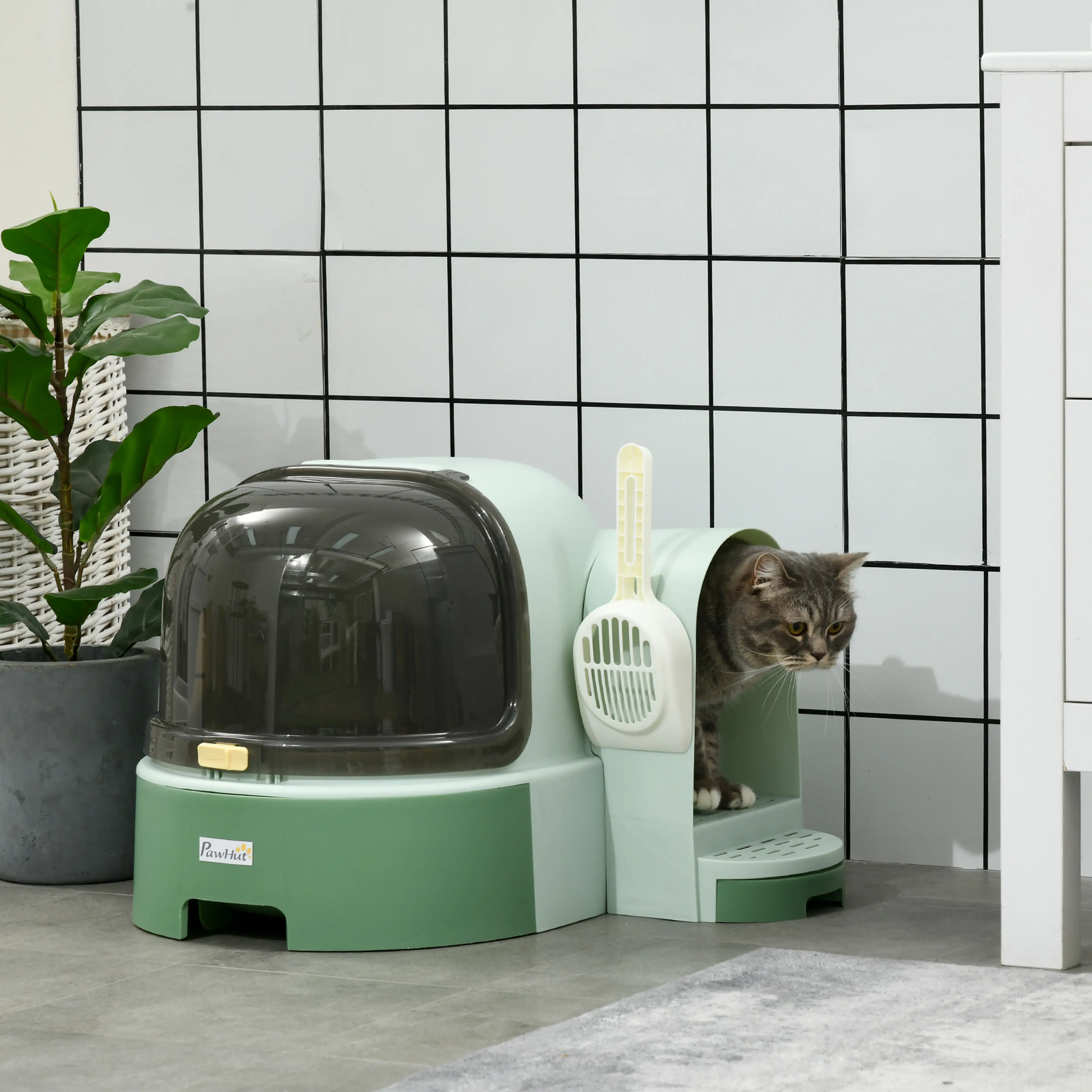 Kattlådan i ett badrum med en katt som tittar ut genom öppningen