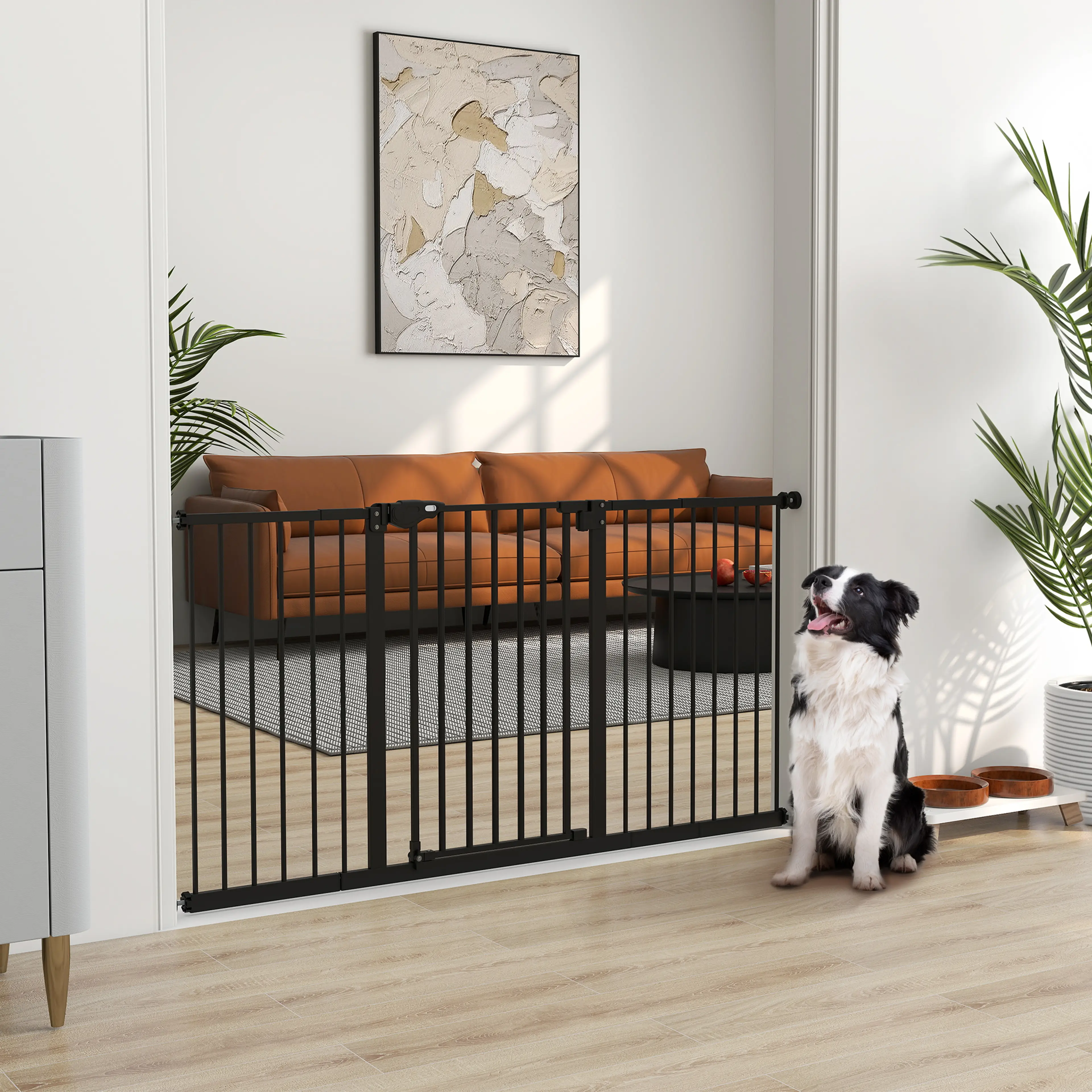 Svartvit hund sitter vid den svarta grinden framför en soffa i ett vardagsrum