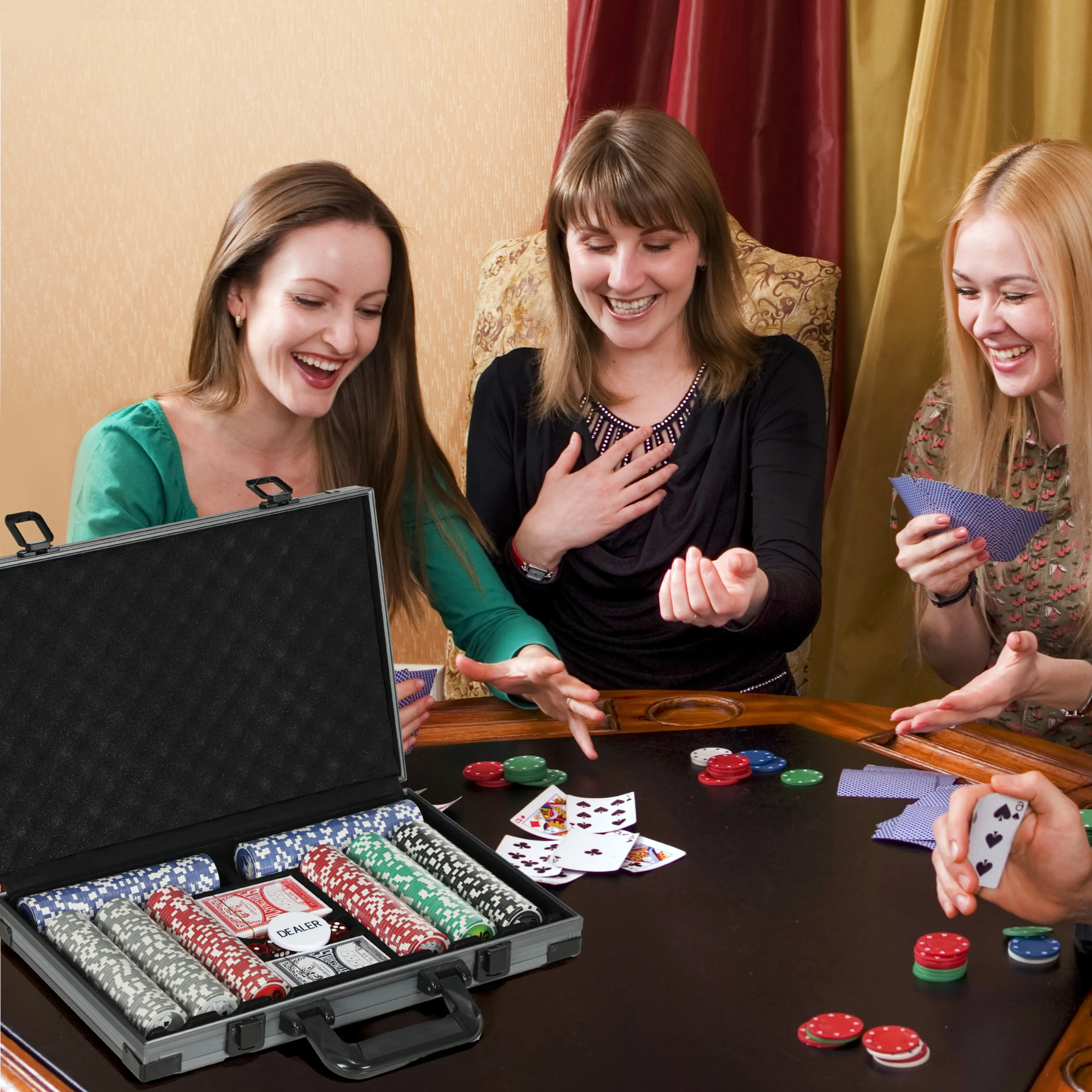 Tre kvinnor spelar kort med marker ur pokerväskan