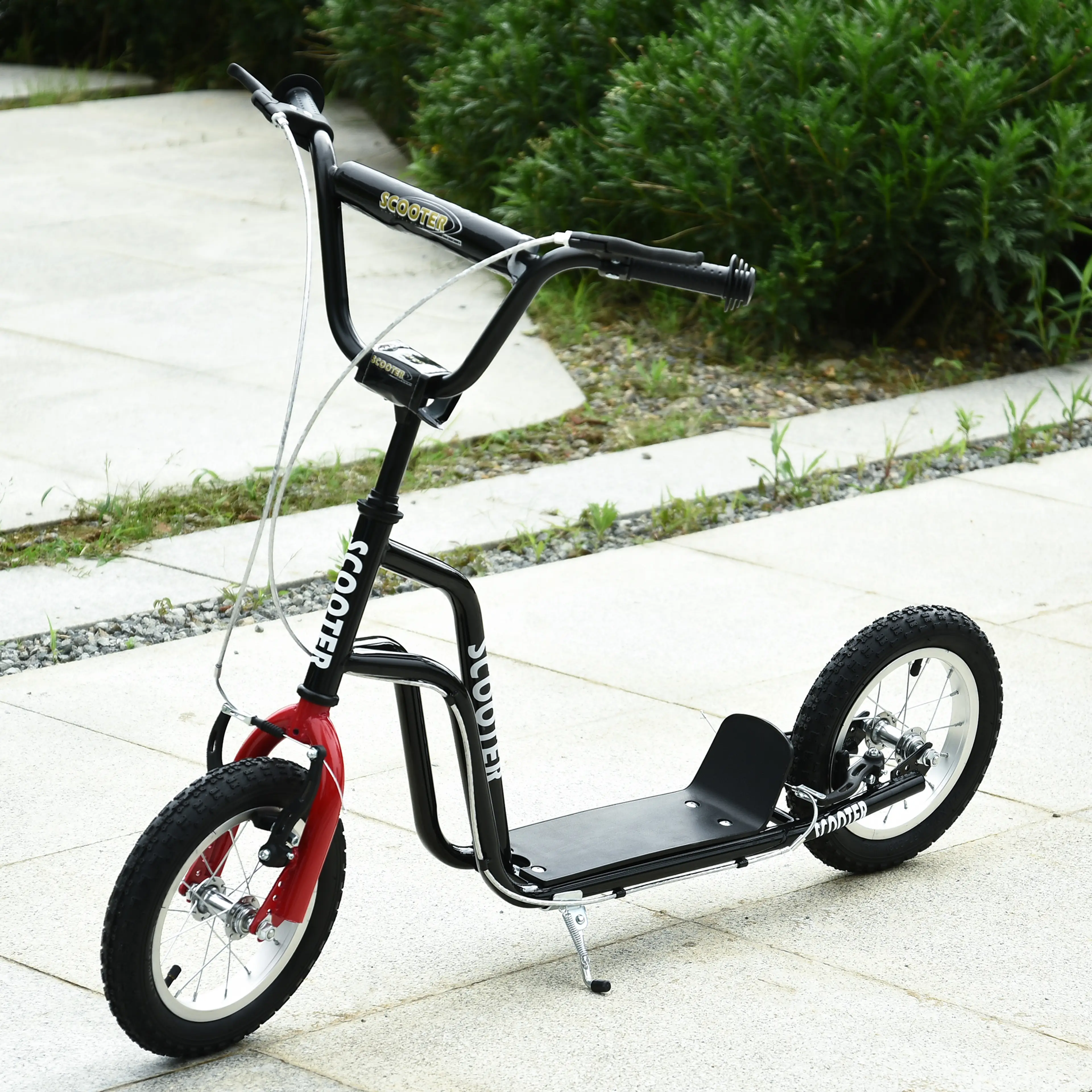 Svart sparkcykel med röd framgaffel parkerad på stenplattor