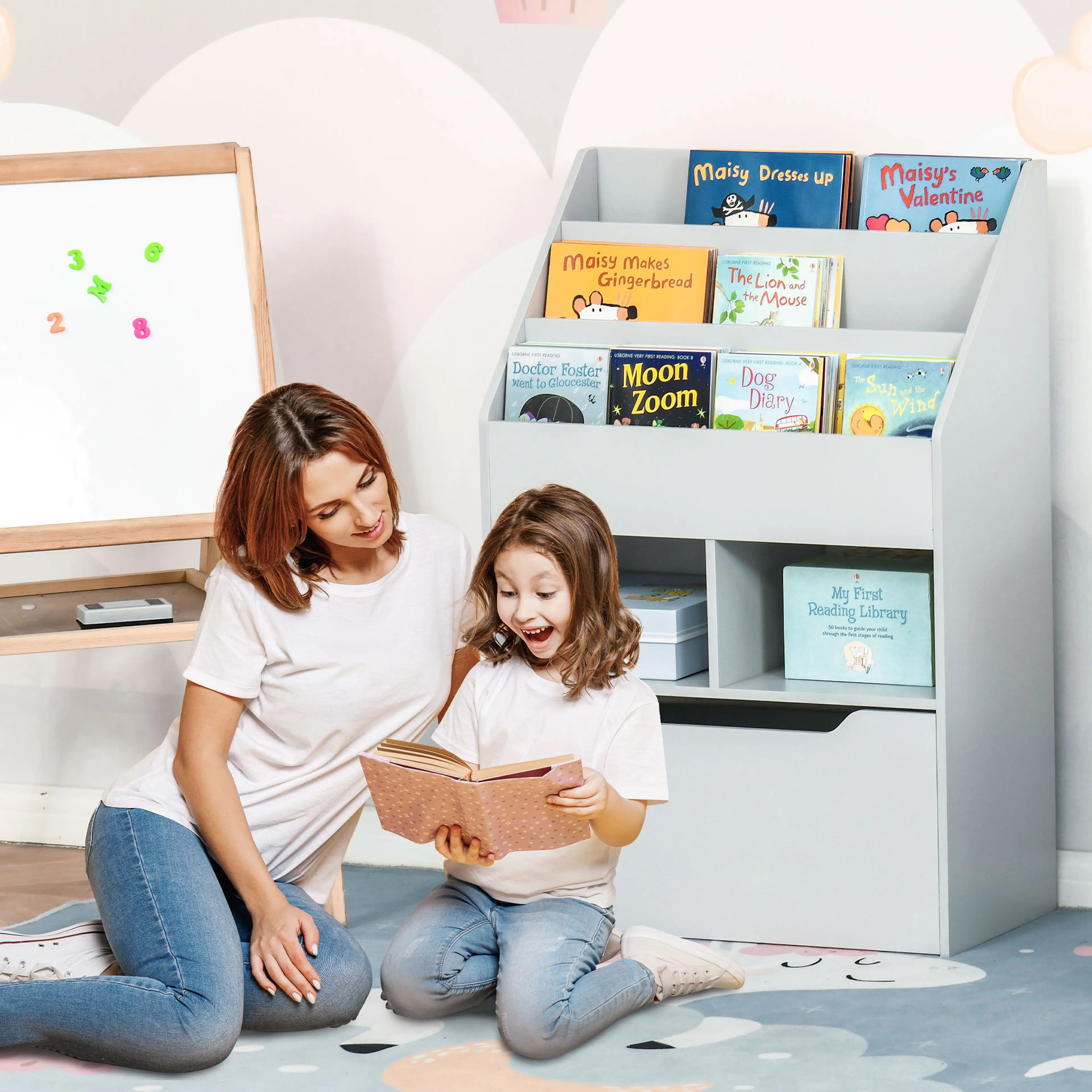 En mamma och en dotter läser en bok framför barnbokhyllan