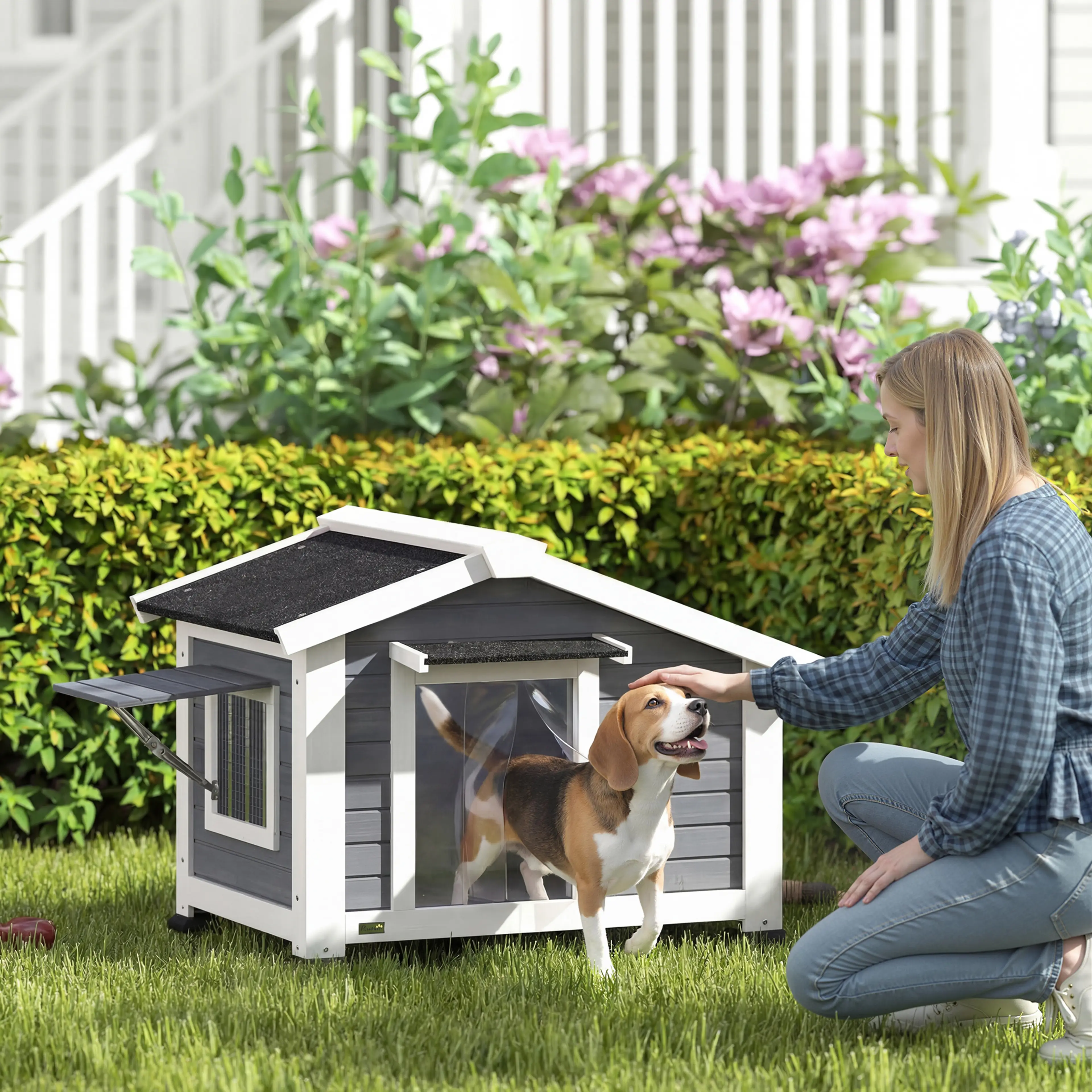 Hundkojan på en gräsmatta med en hund som tittar ut genom dörröppningen