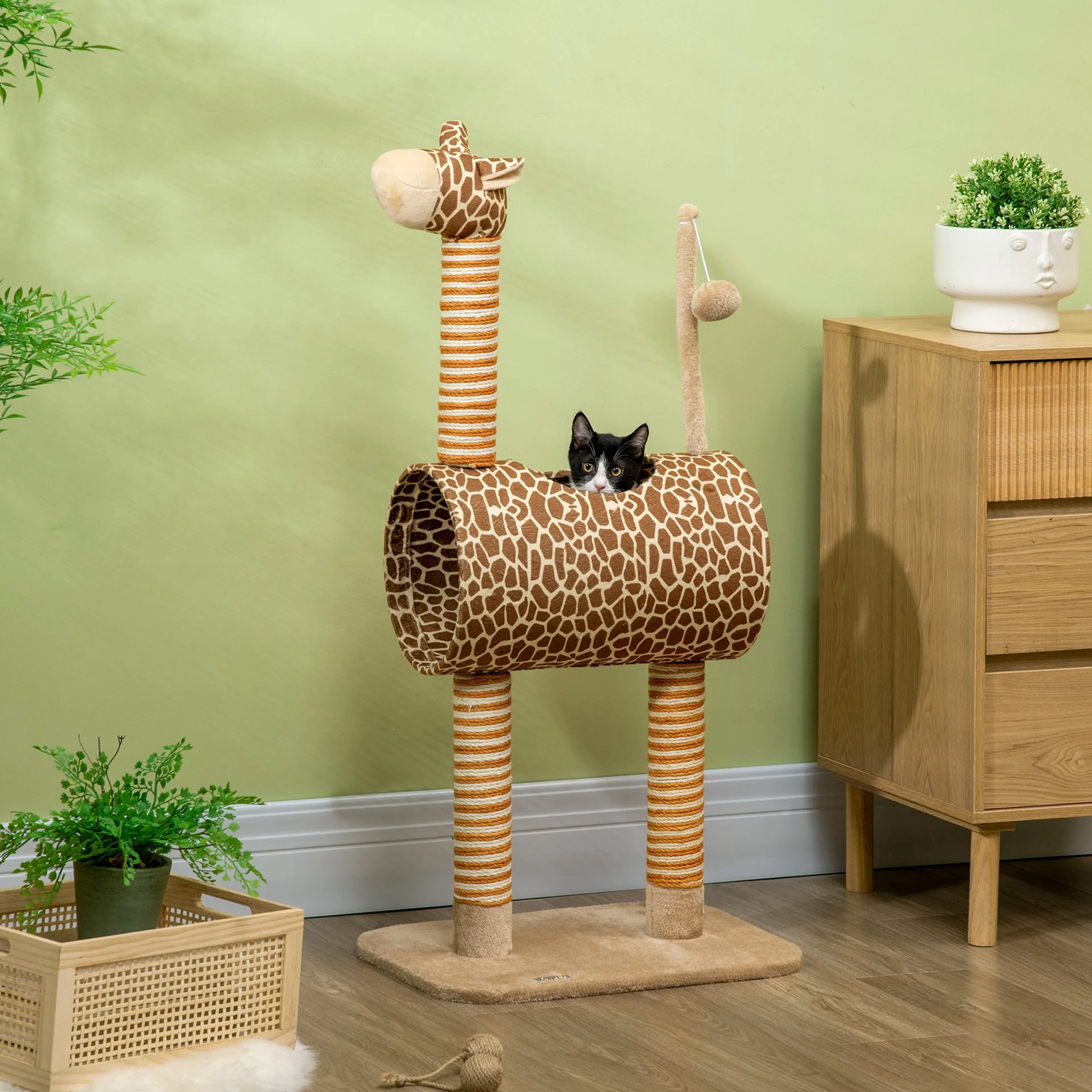 Giraffklösträdet mot en grön vägg med en katt liggande ovanpå tunneln