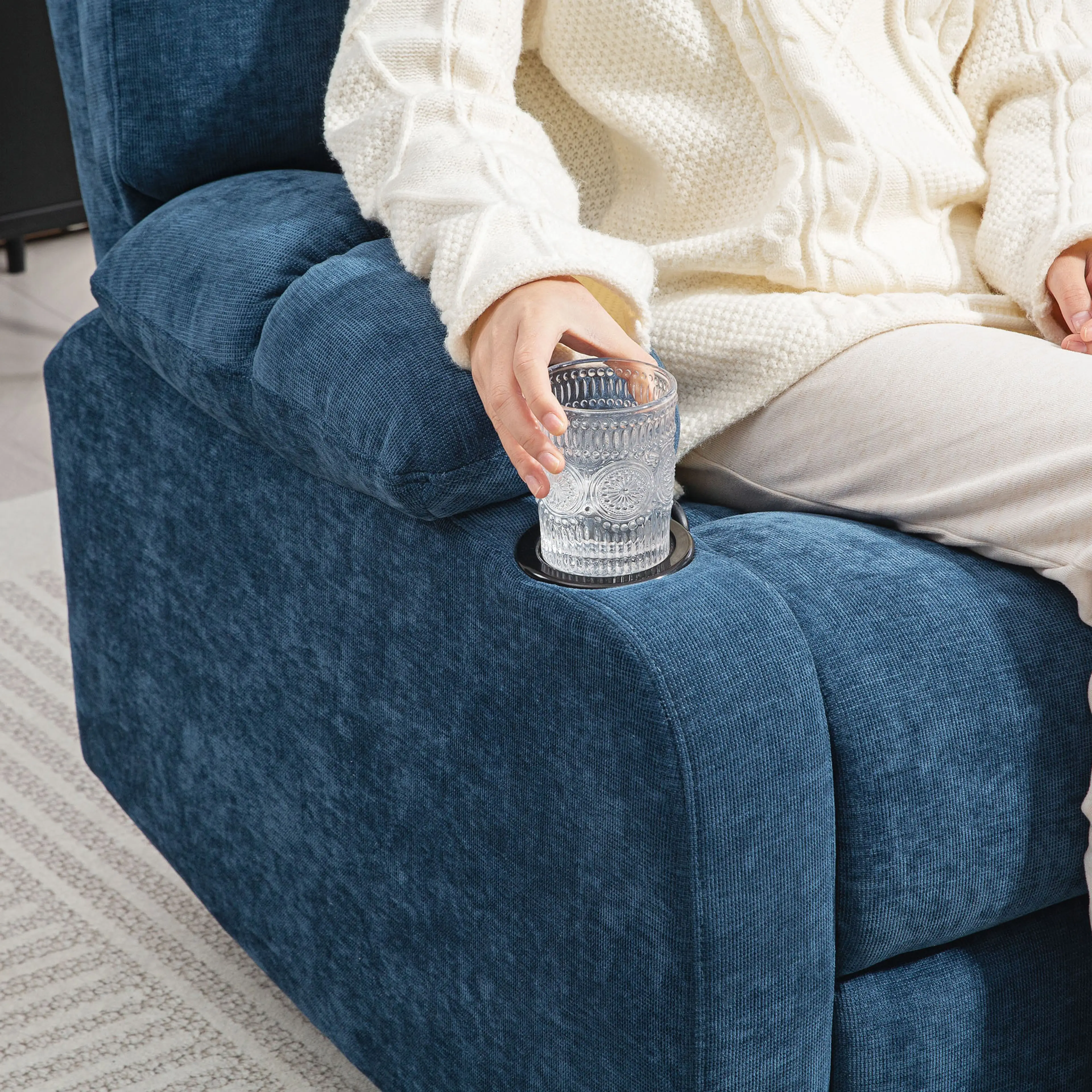 Hand som ställer ett glas i den infällda mugghållaren