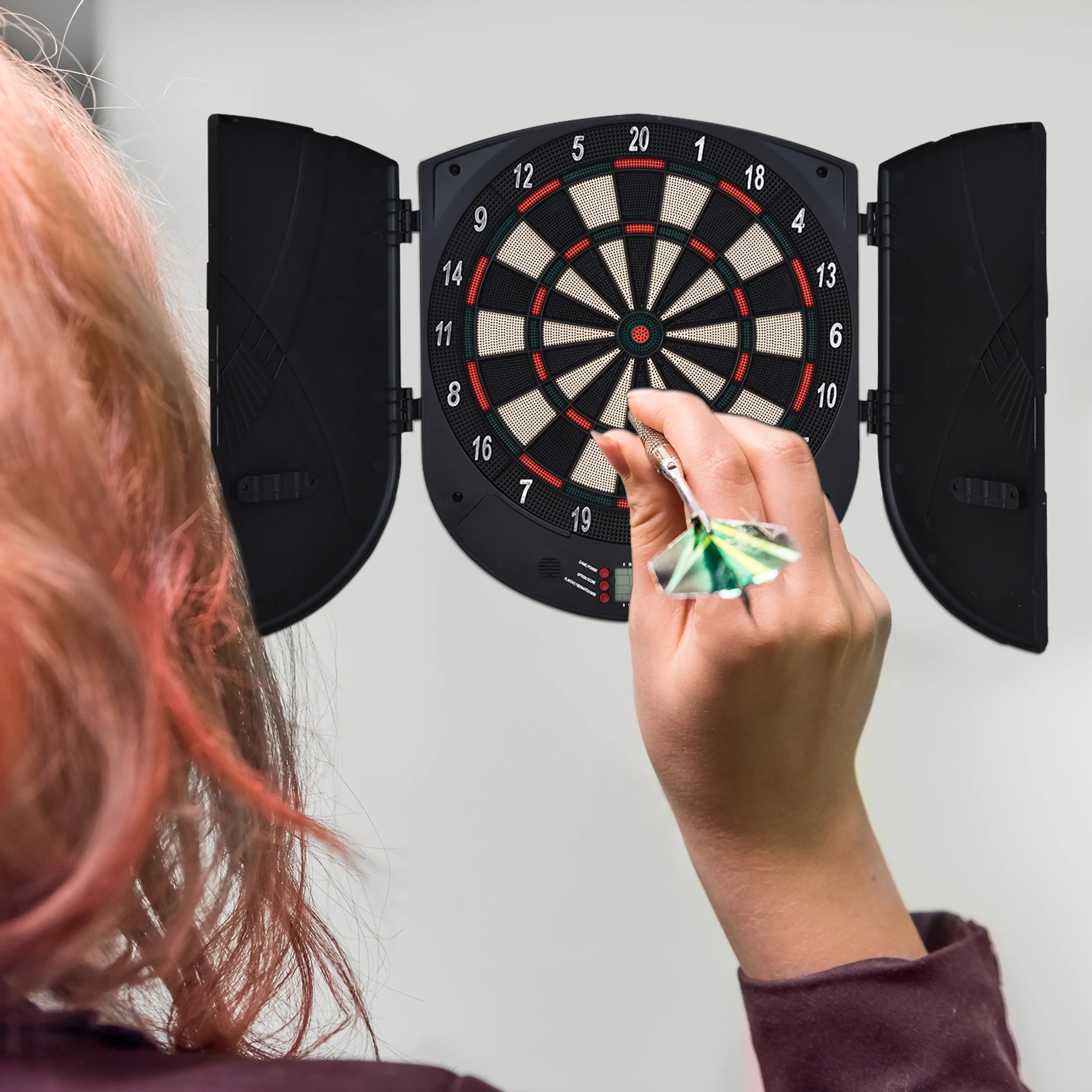 En person kastar en pil mot darttavlan på väggen